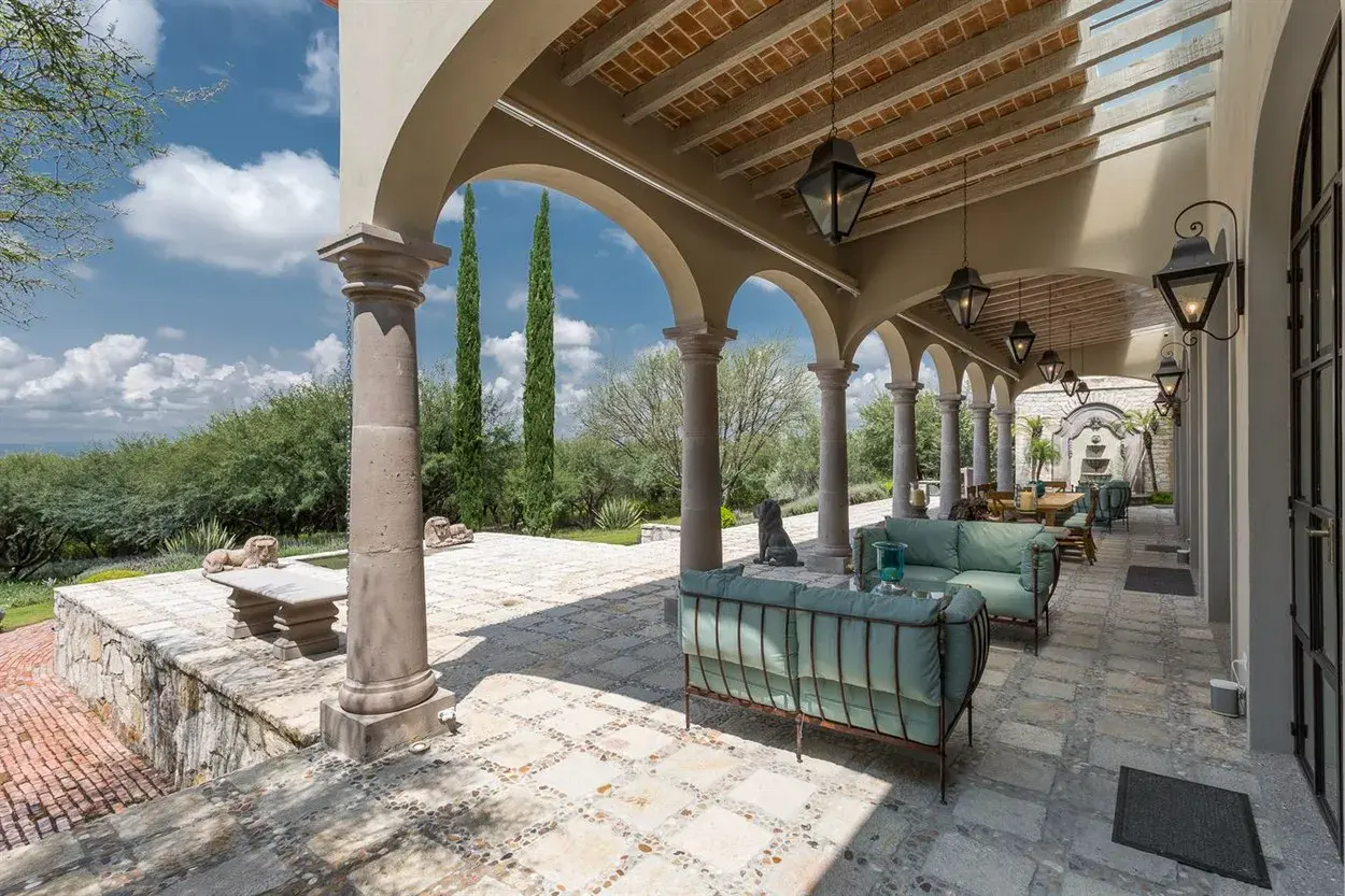Finca Garambullos, stone arcade with teal outdoor seating and views of the hills, San Miguel de Allende