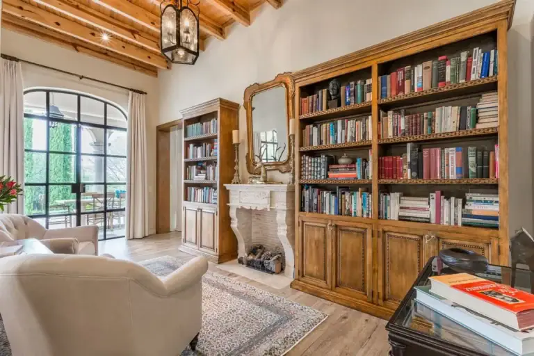 Finca Garambullos, library with a stone fireplace and floor-to-ceiling bookshelves, San Miguel de Allende