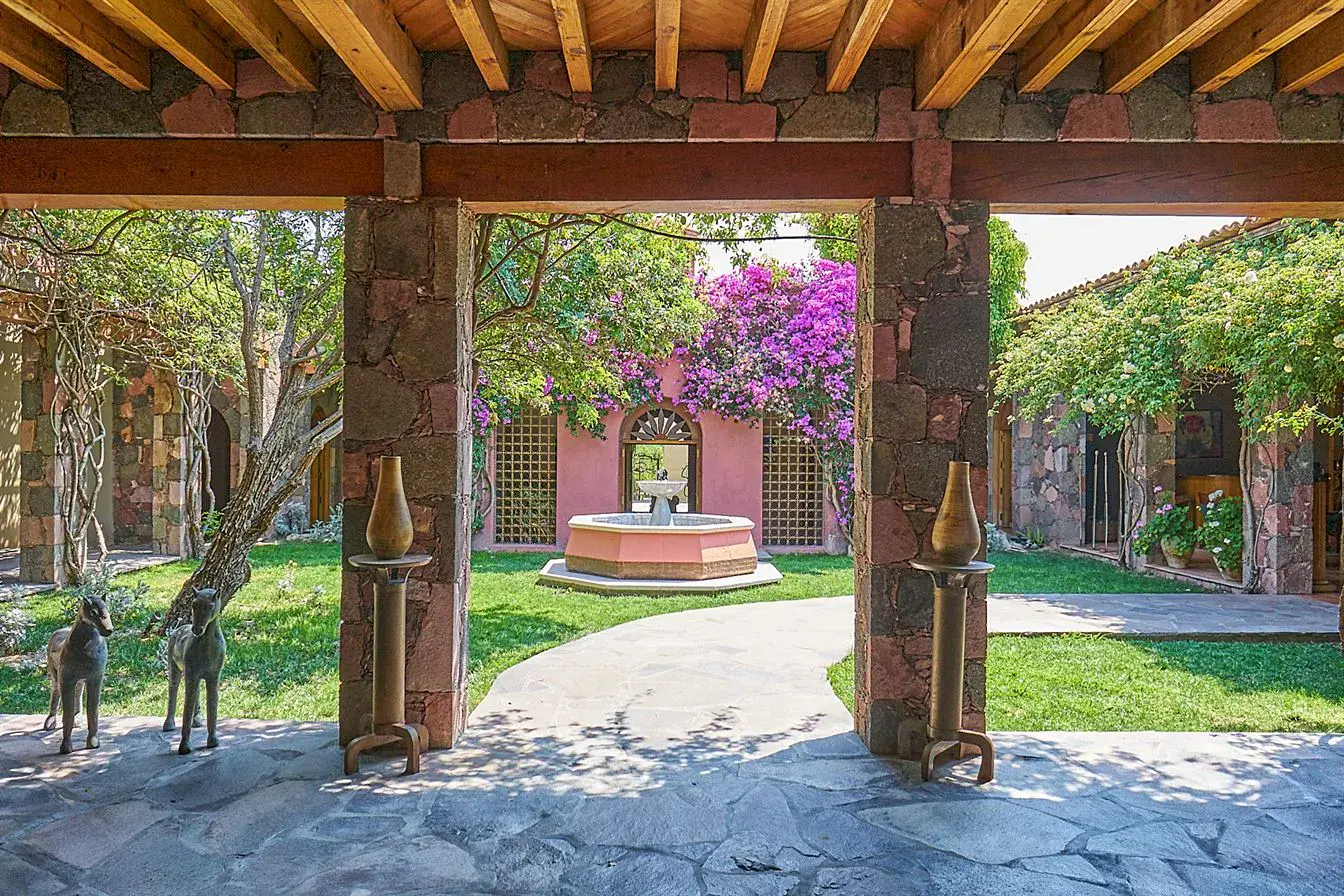 Hacienda Candelaria, stone columned loggia framing a courtyard fountain and bougainvillea, San Miguel de Allende