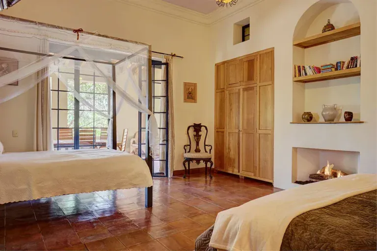 Hacienda Candelaria, bedroom with a bed canopy, a fireplace and arched alcoves, San Miguel de Allende
