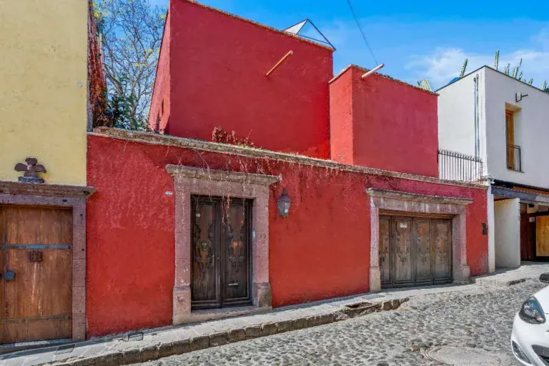 Hotel Casa Luna, red stucco street facade with two wood doors on a cobblestone street, San Miguel de Allende