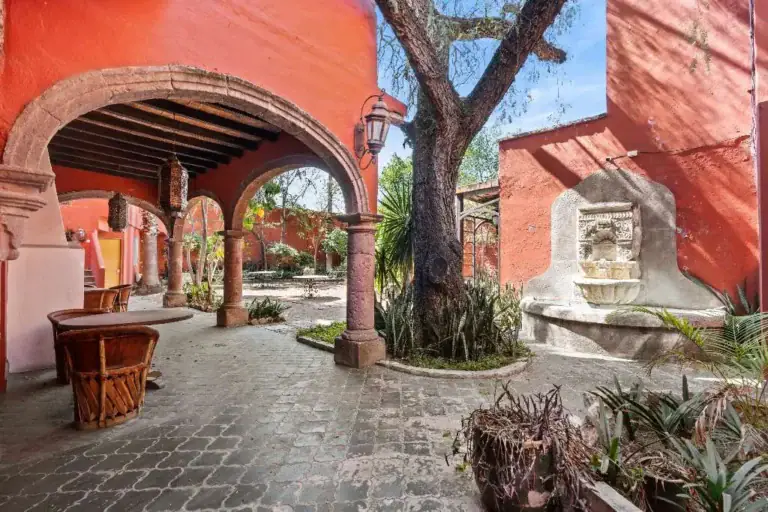 Hotel Casa Luna, courtyard arches with a stone fountain and a large tree, San Miguel de Allende
