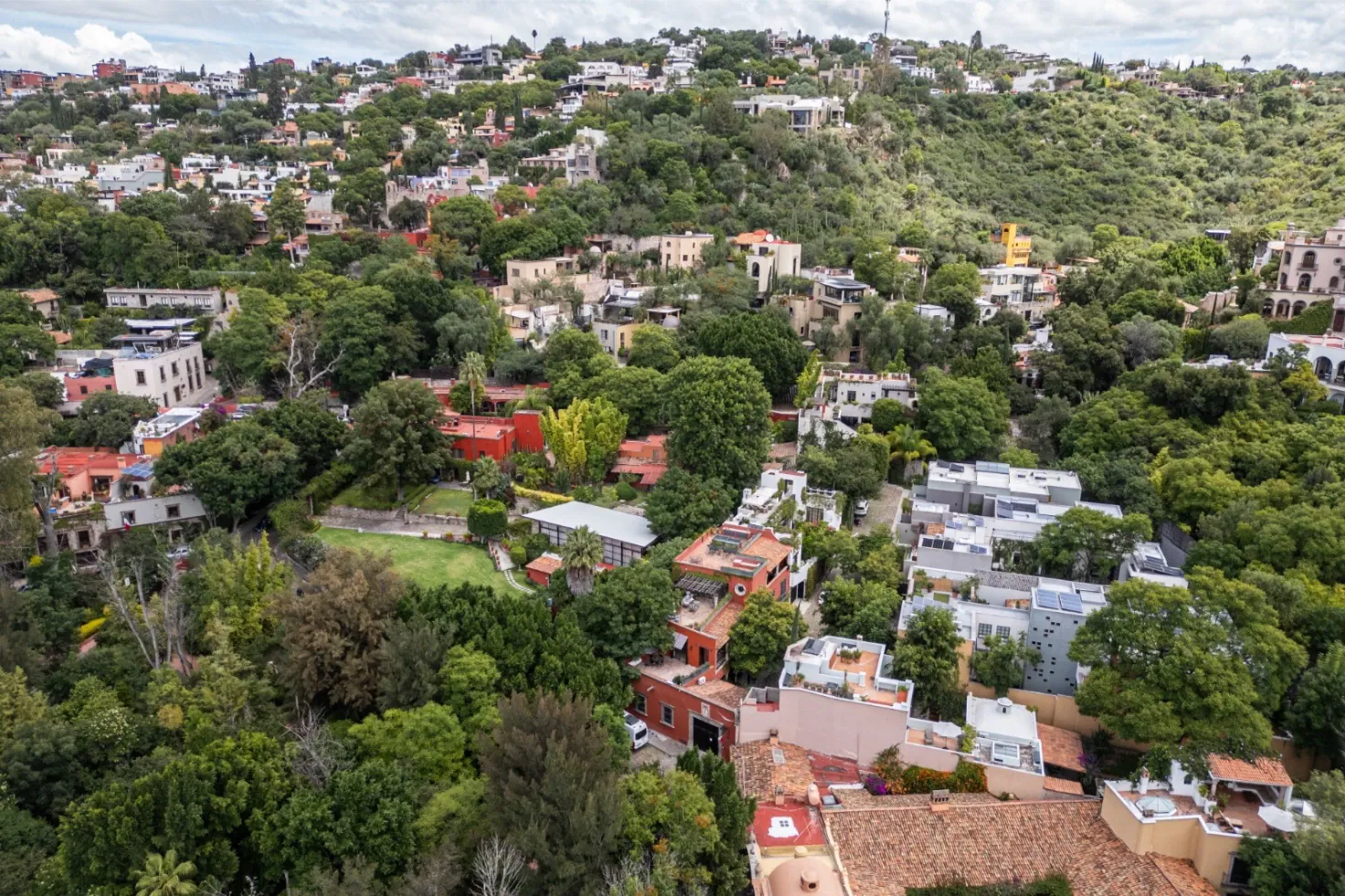 Casa Santa Mónica, aerial view of the hillside neighborhood with homes among trees, San Miguel de Allende