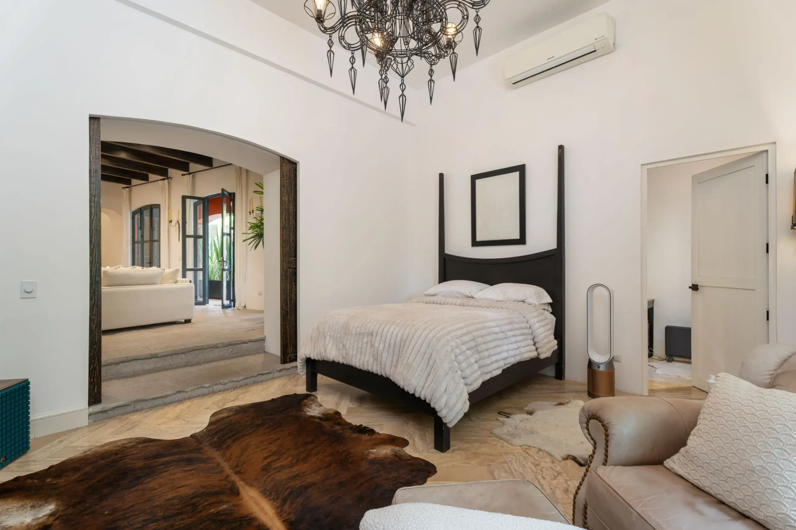 Casa Santa Mónica, guest bedroom with a four-poster bed and an arched opening to the living room, San Miguel de Allende