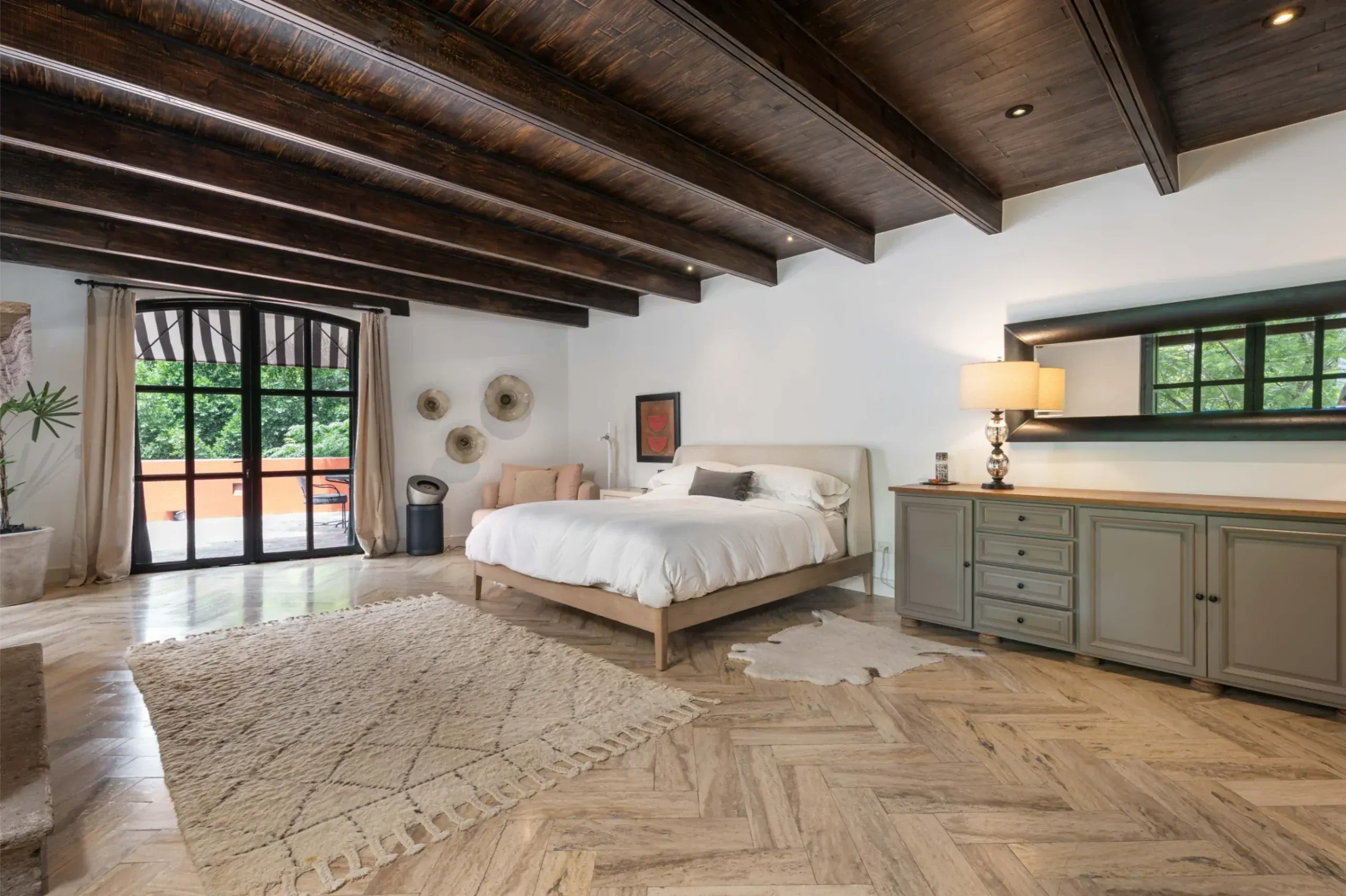 Casa Santa Mónica, primary bedroom with a beamed ceiling and a herringbone floor, San Miguel de Allende