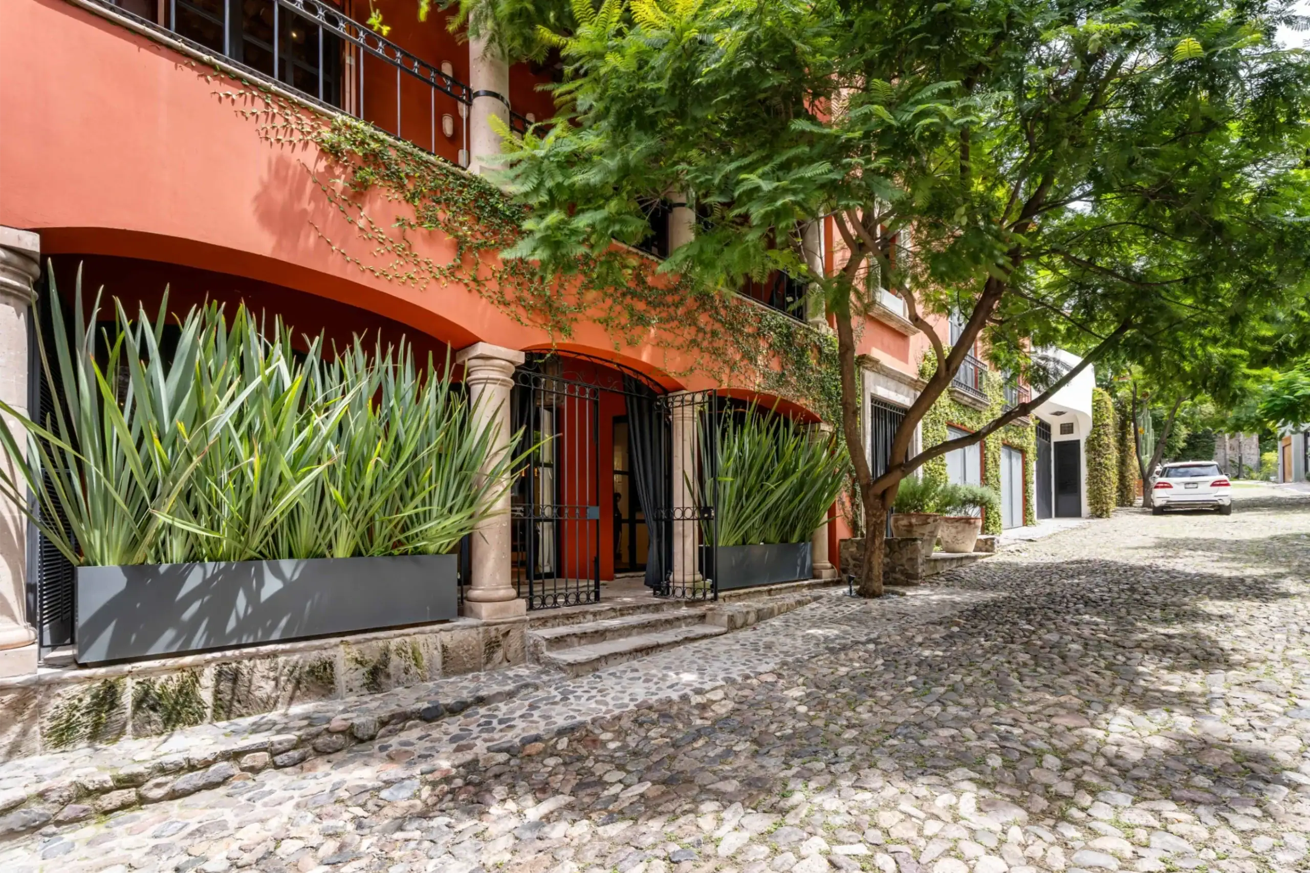 Casa Santa Mónica, street frontage with planters and an arched entrance, San Miguel de Allende