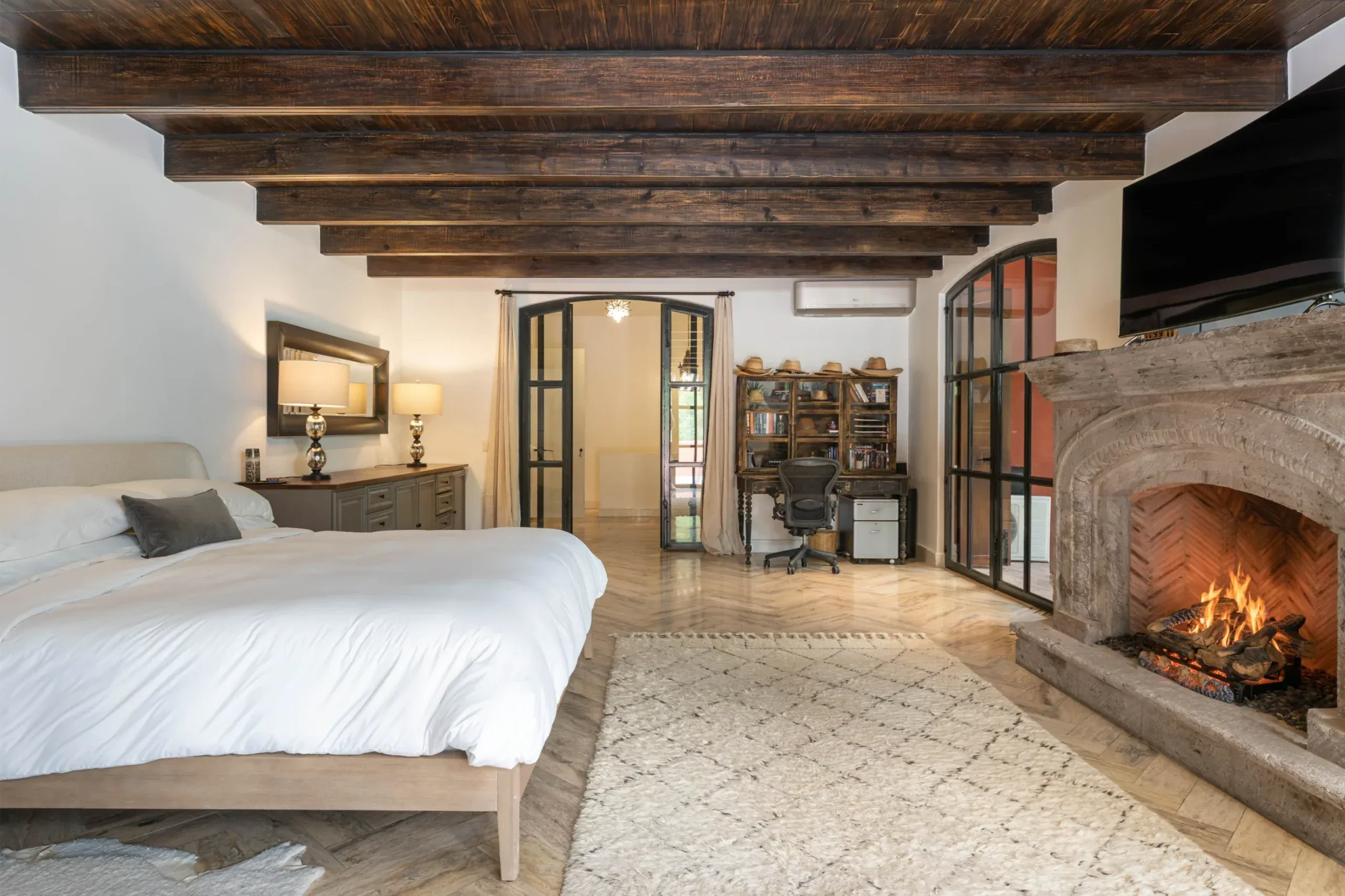 Casa Santa Mónica, primary suite with a stone fireplace and a beamed ceiling, San Miguel de Allende