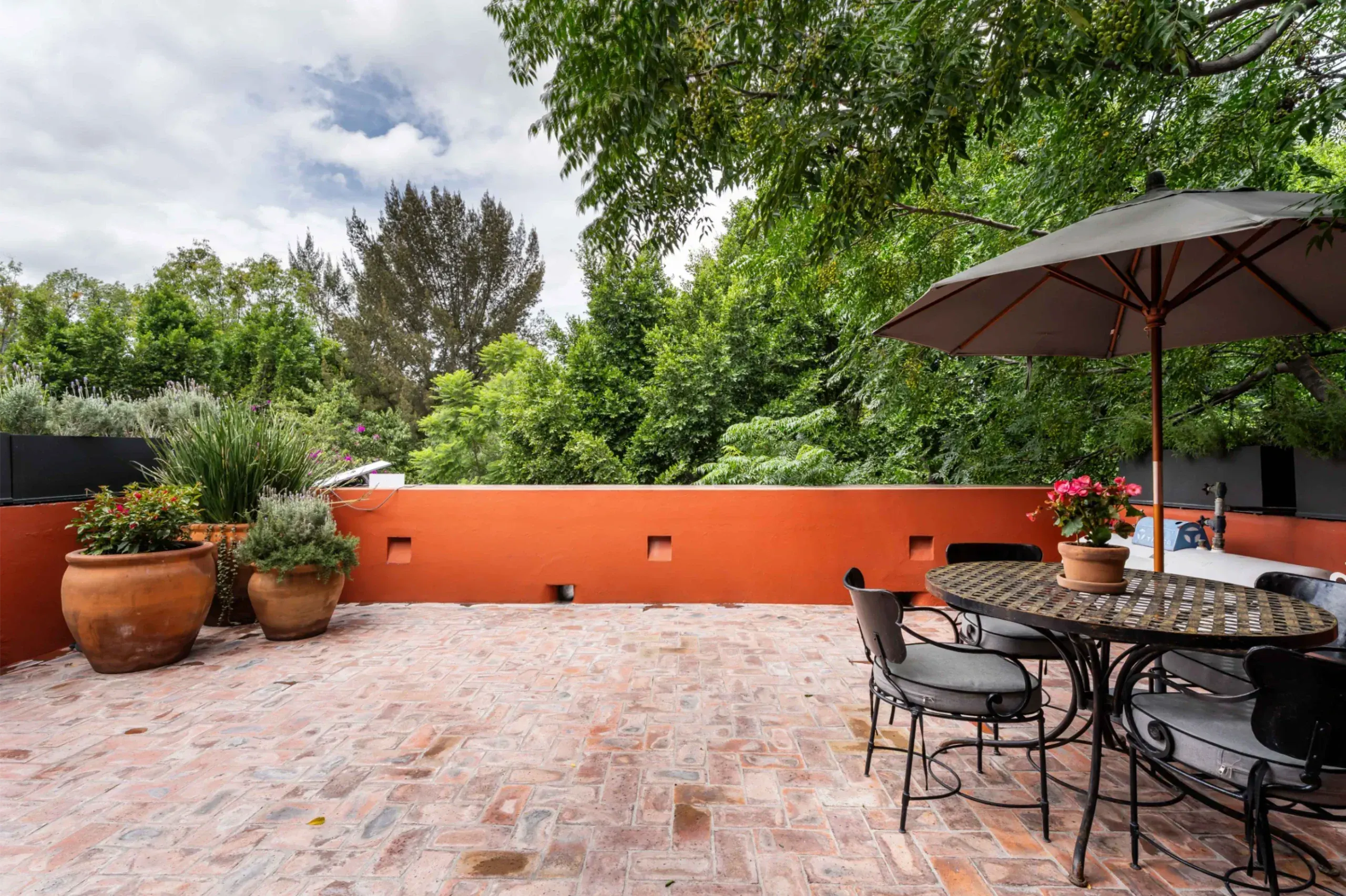 Casa Santa Mónica, terrace with a dining table, umbrellas and tree views, San Miguel de Allende
