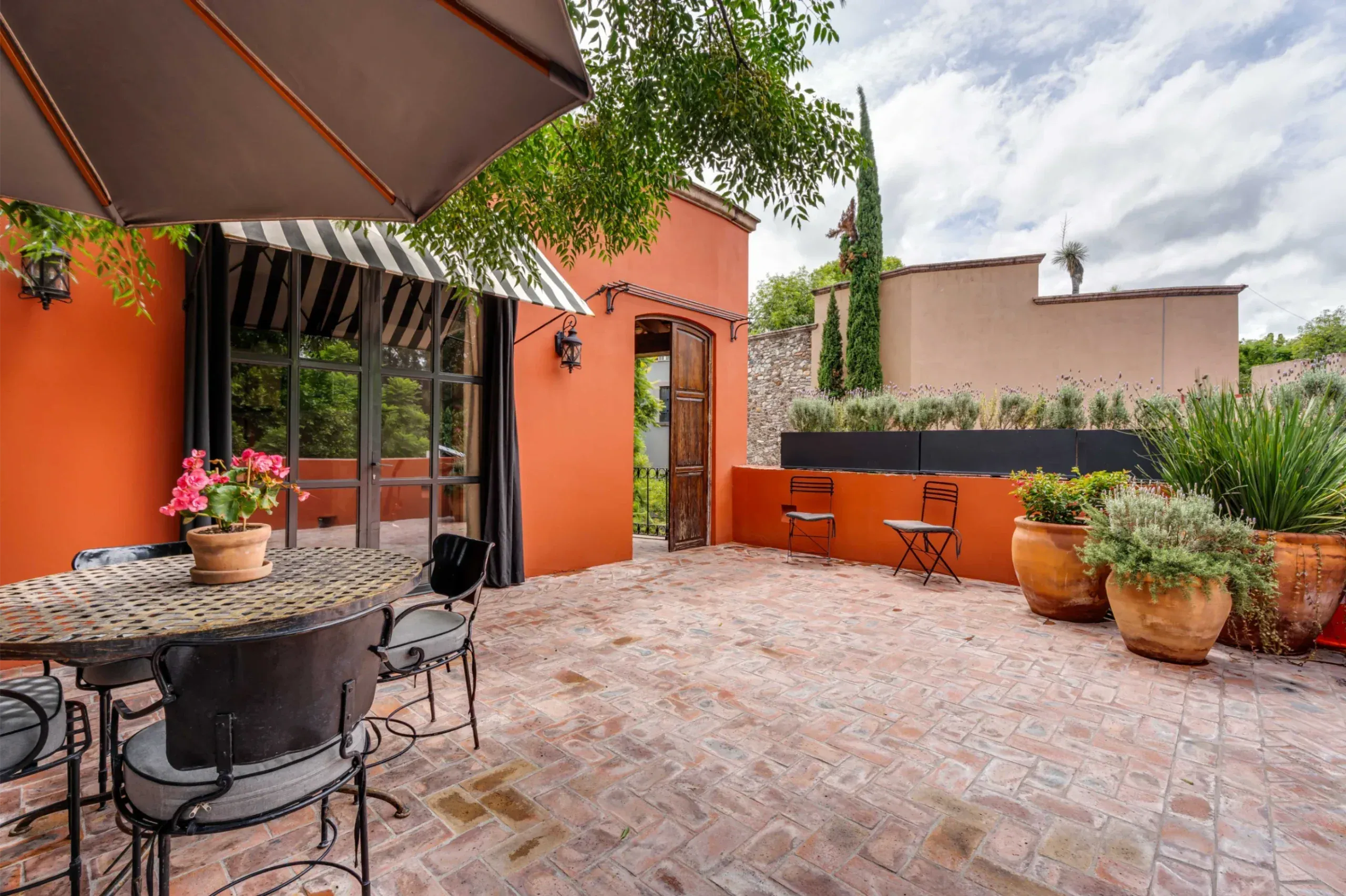 Casa Santa Mónica, terrace with a mosaic table and an awning over the doors, San Miguel de Allende