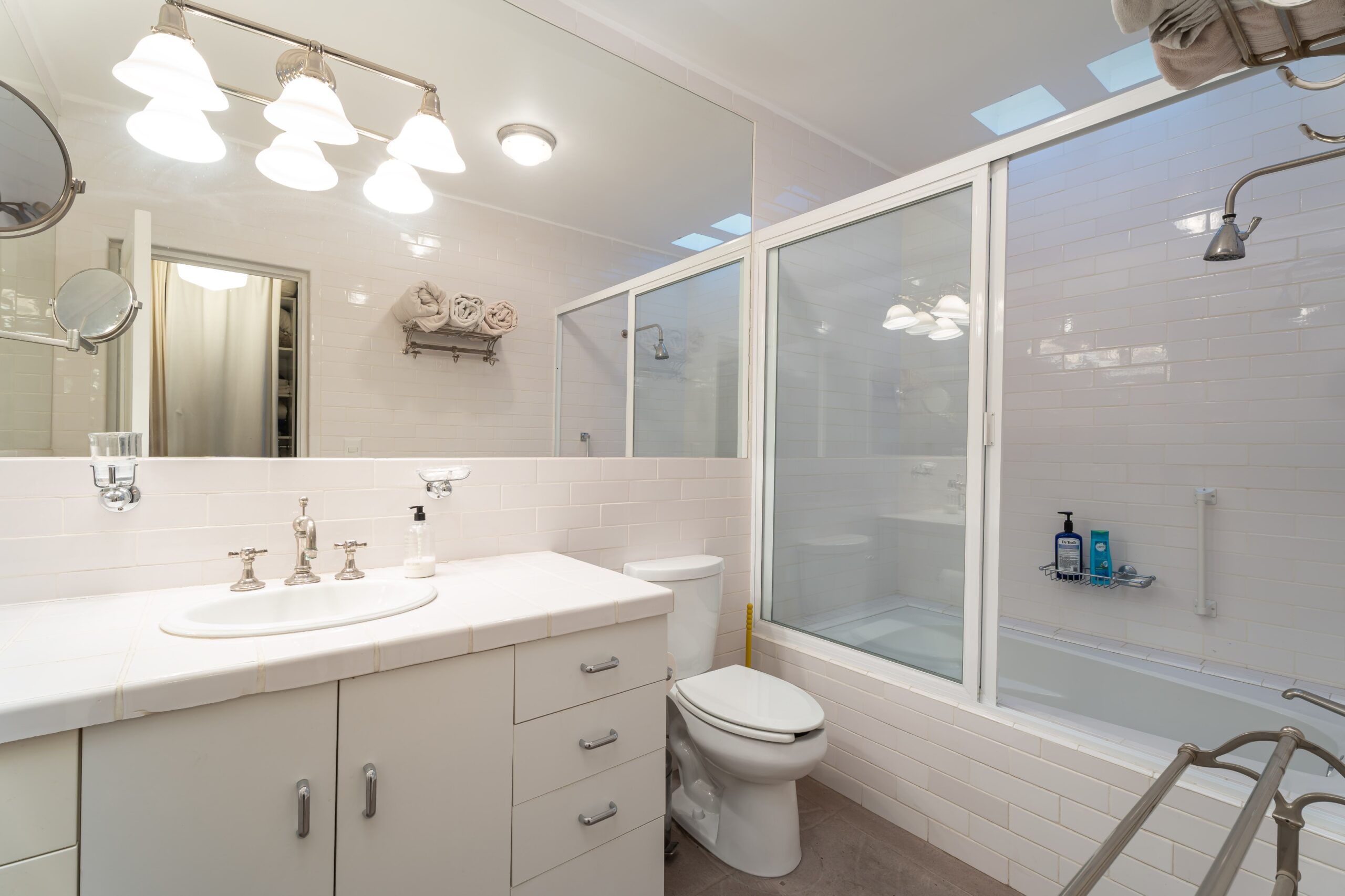 Bright, modern bathroom with a double-sink vanity, large mirror, and glass-enclosed shower, San Miguel de Allende