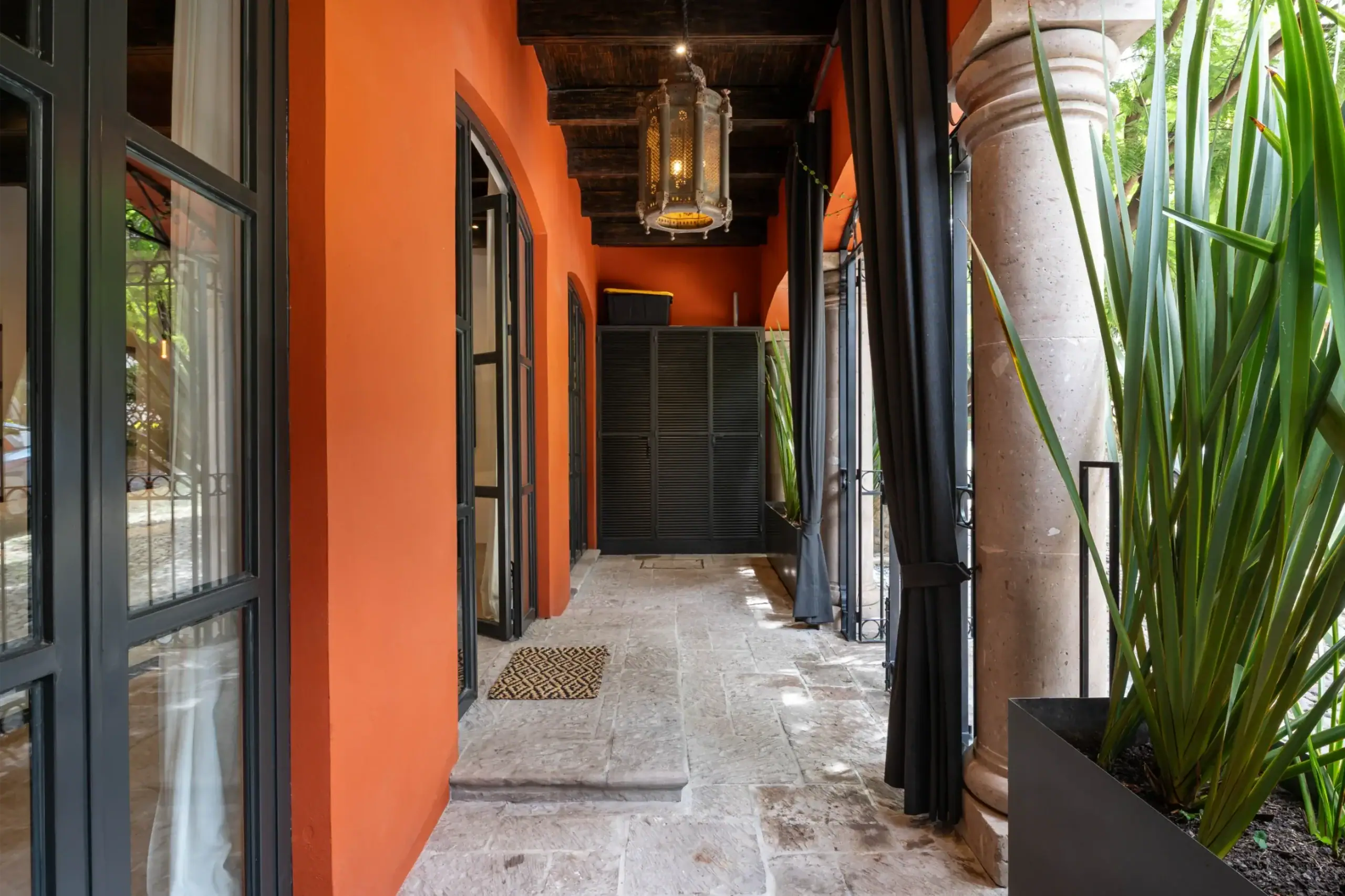 Casa Santa Mónica, covered gallery with steel-framed doors and a lantern, San Miguel de Allende