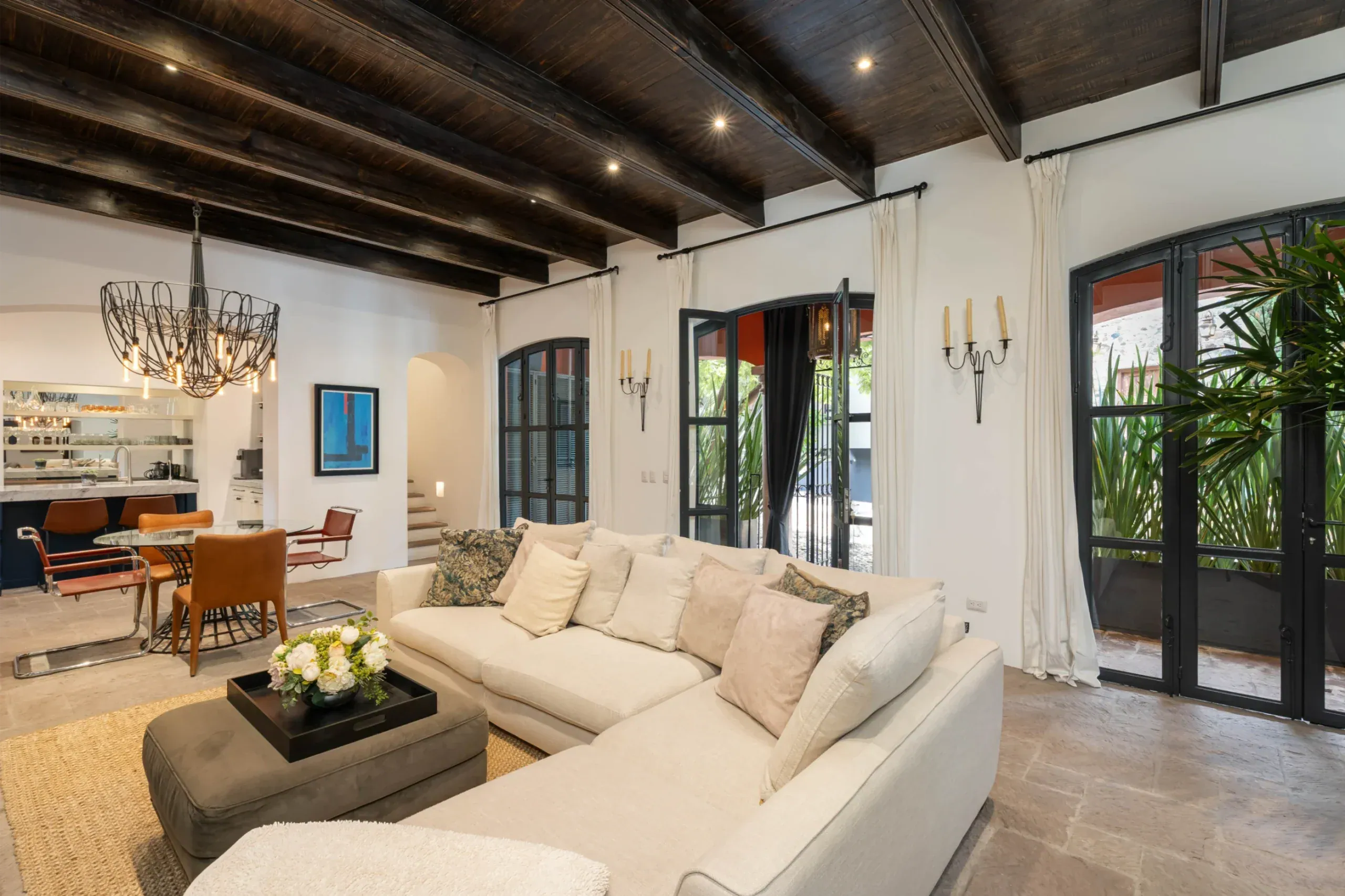 Casa Santa Mónica, living room with a white sectional and steel-framed doors to the garden, San Miguel de Allende