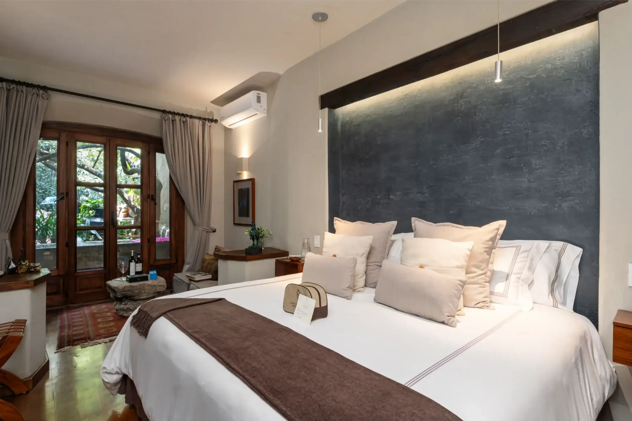 Hotel bedroom with two large white beds, brown runners, and a dark accent wall, San Miguel de Allende