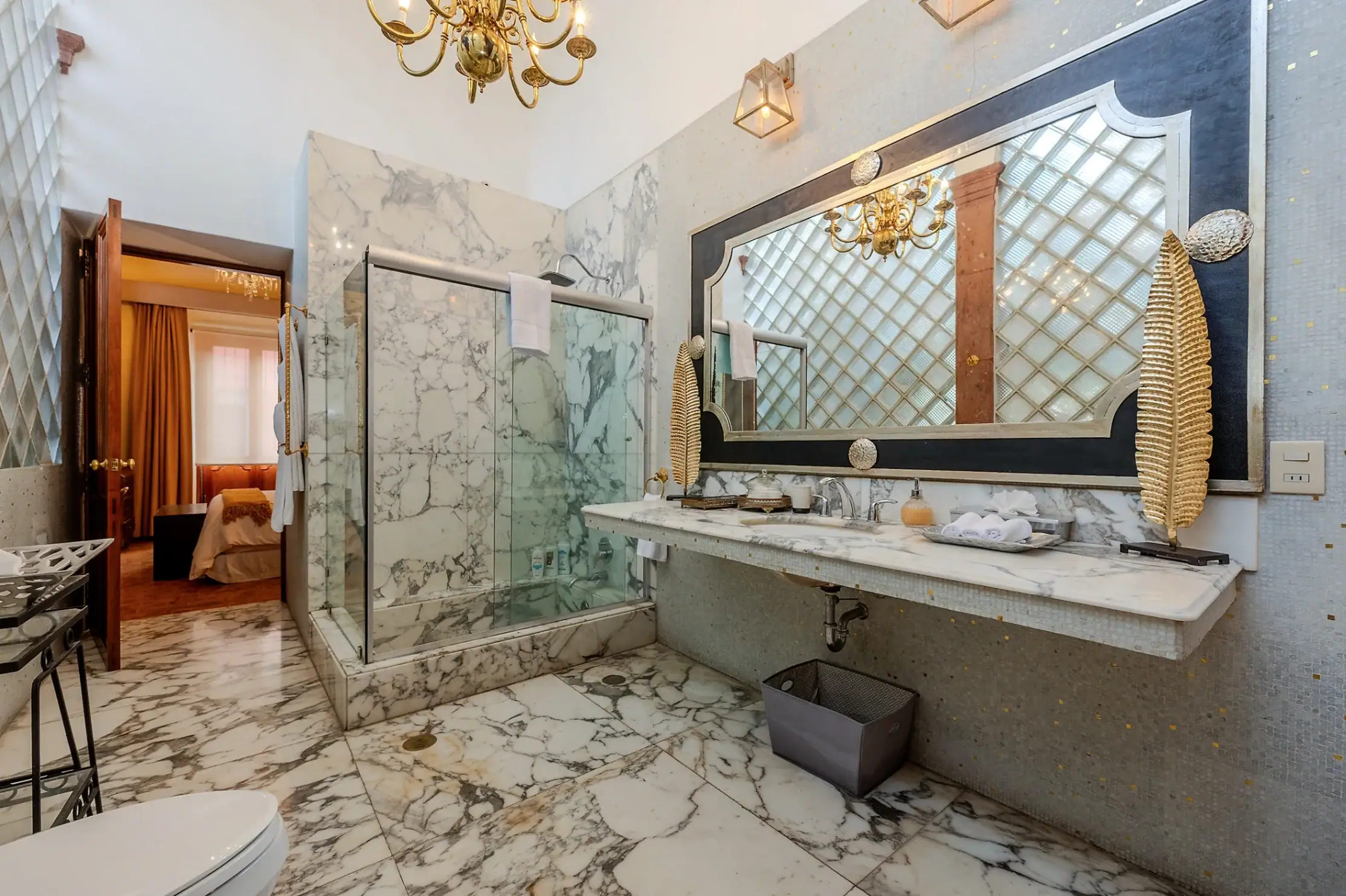 Luxurious marble bathroom with a double sink, large framed mirror, and glass-enclosed shower, San Miguel de Allende