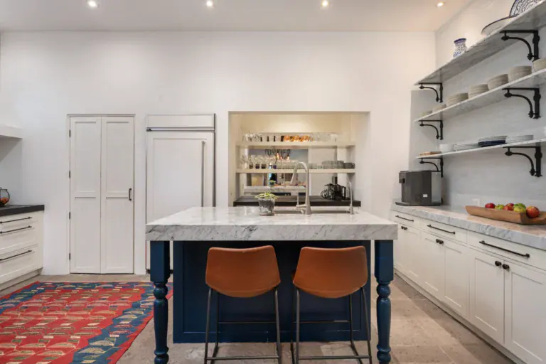 Casa Santa Mónica, kitchen with white cabinets, open shelves and leather bar stools, San Miguel de Allende