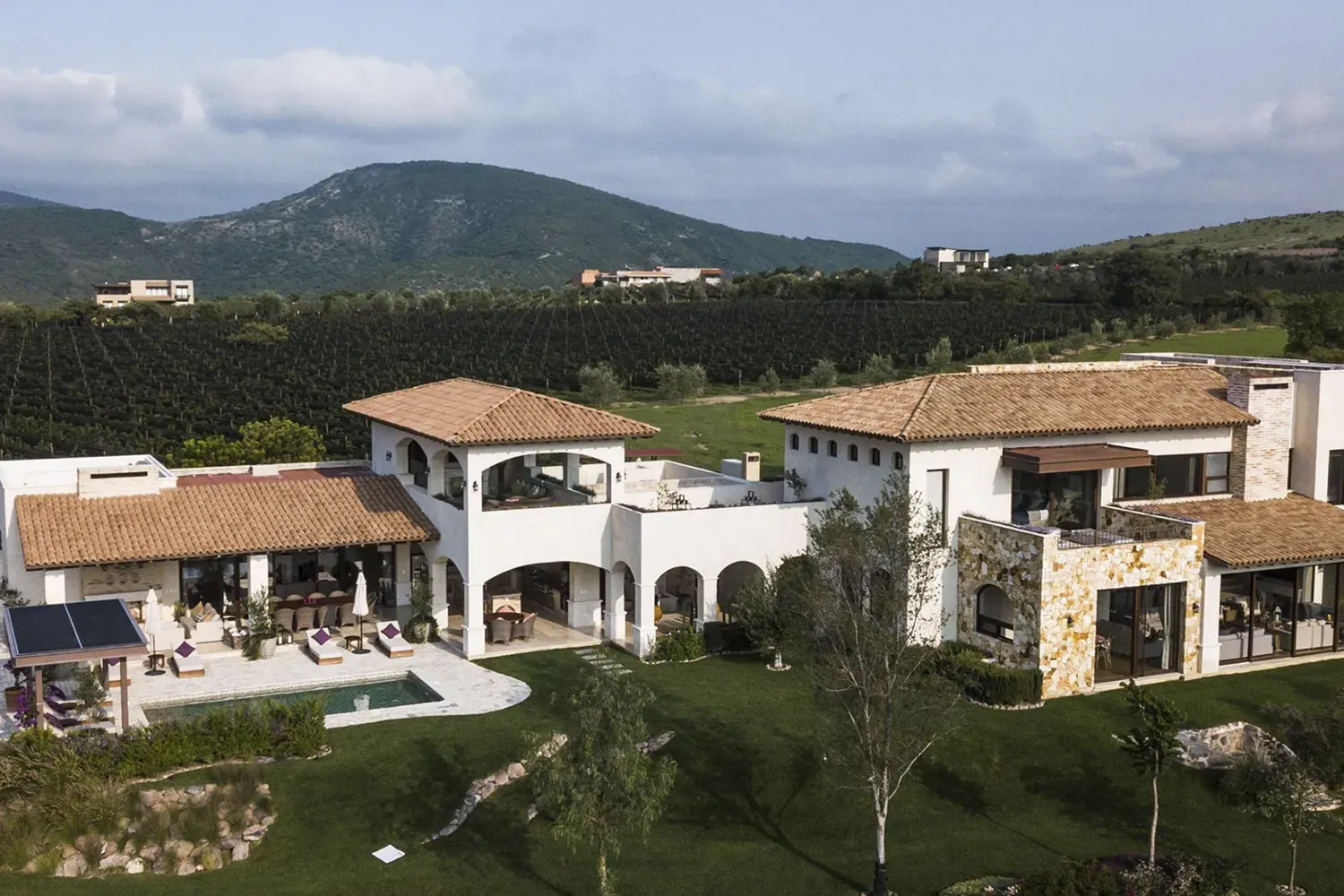 Mañanitas Residence, aerial view of the stone and stucco house with tile roofs and mountain views, San Miguel de Allende