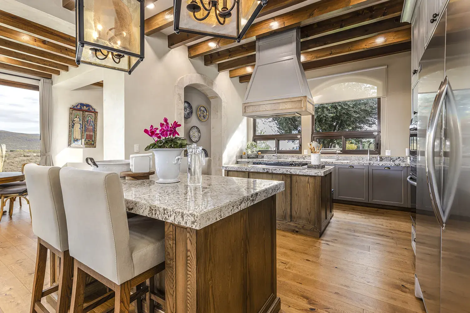 Mañanitas Residence, kitchen with a granite island, white stools and lantern pendants, San Miguel de Allende