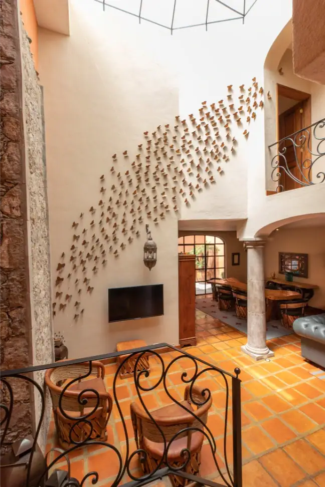 Casa Brillante, staircase with a wrought-iron railing and a decorative wall of sculpted ornaments, San Miguel de Allende