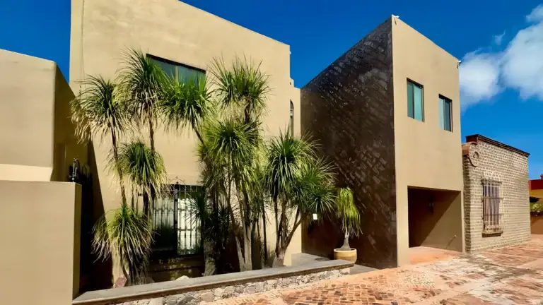 Raíz de las Nubes, exterior of the stepped modern house with palm trees and a brick-paved terrace, San Miguel de Allende