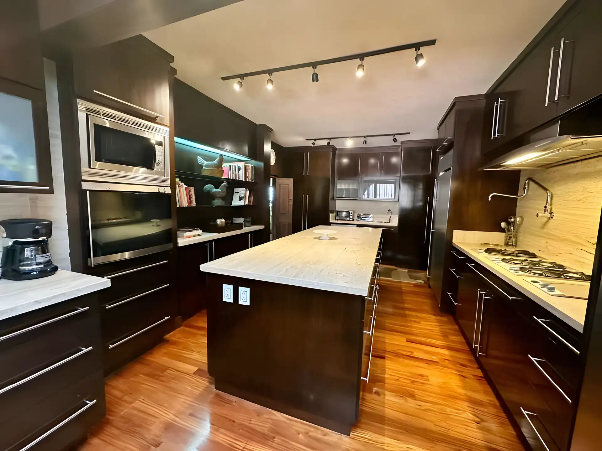 Raíz de las Nubes, kitchen with dark cabinets, a granite island, built-in oven and a gas cooktop, San Miguel de Allende