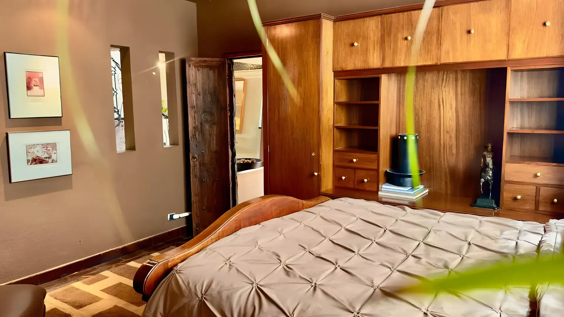 Raíz de las Nubes, bedroom with a pleated bedspread, built-in wood cabinets and framed pictures, San Miguel de Allende
