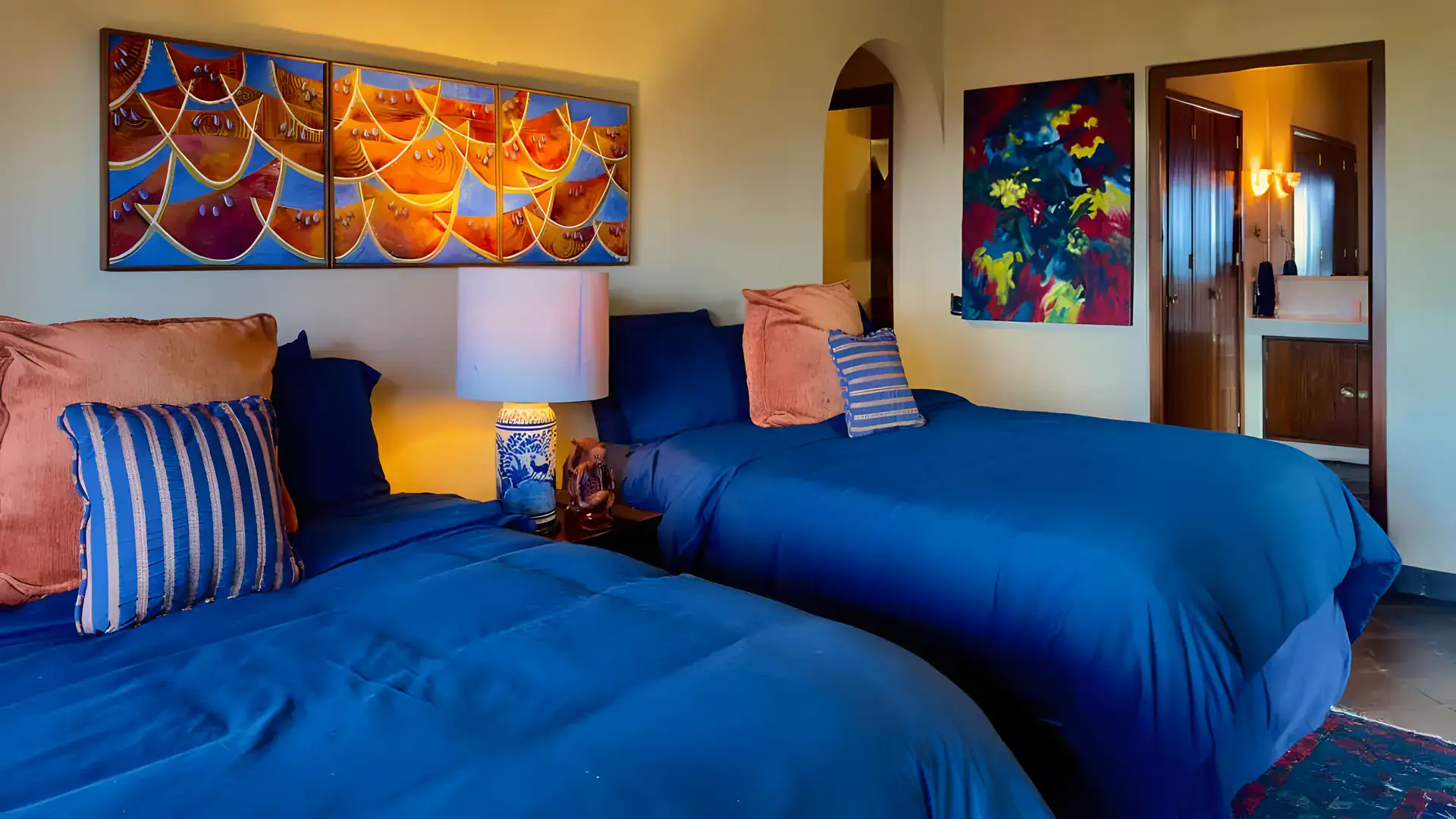 Raíz de las Nubes, guest bedroom with two blue beds and colorful artwork, San Miguel de Allende