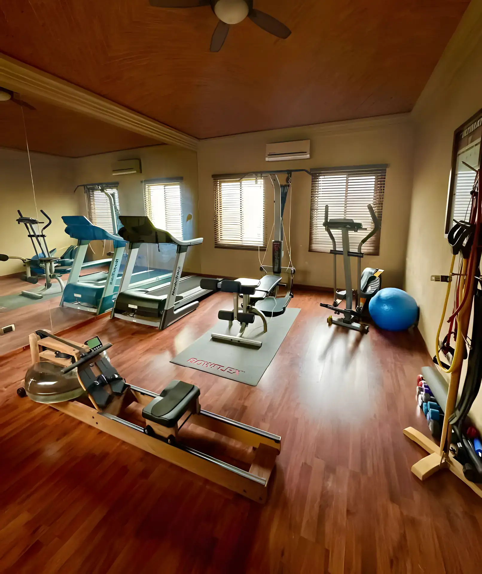Raíz de las Nubes, home gym with treadmills, an elliptical and a rowing machine under a brick ceiling, San Miguel de Allende