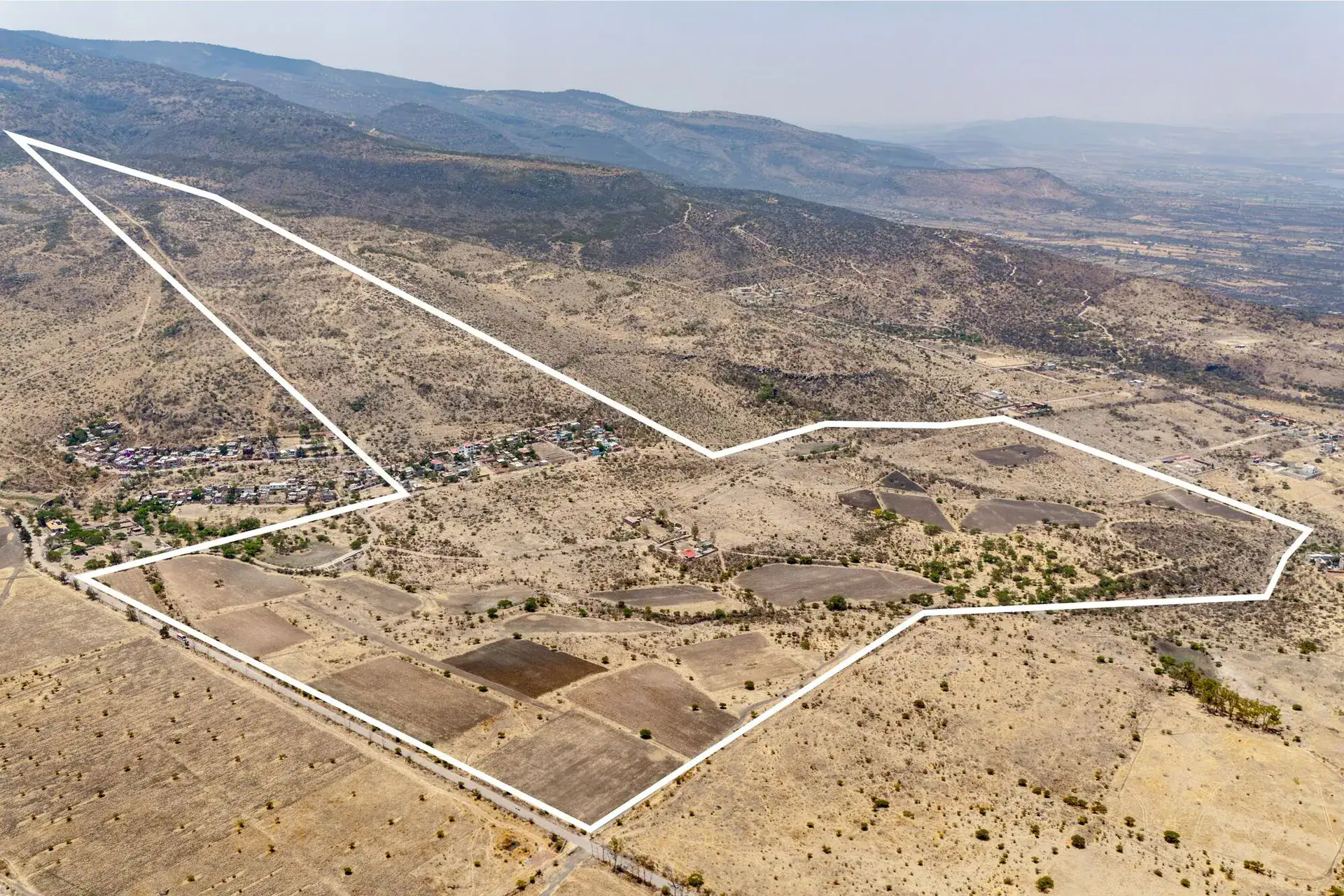 Rancho Guadalupe, aerial view of the parcel boundary outlined in white across plowed fields below the hills, San Miguel de Allende