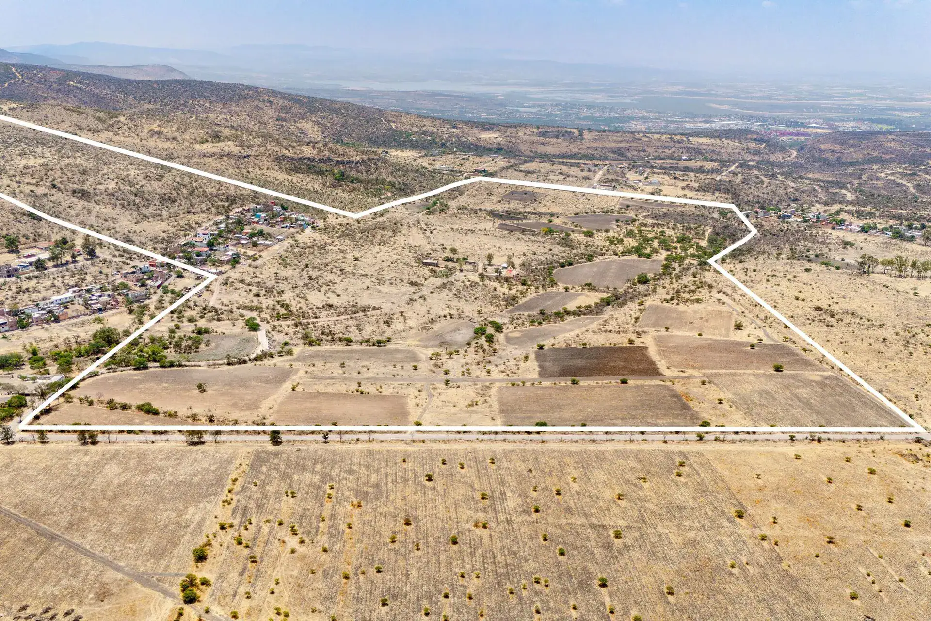 Rancho Guadalupe, aerial view of the white parcel boundary across scrub and plowed fields with a village at the left, San Miguel de Allende