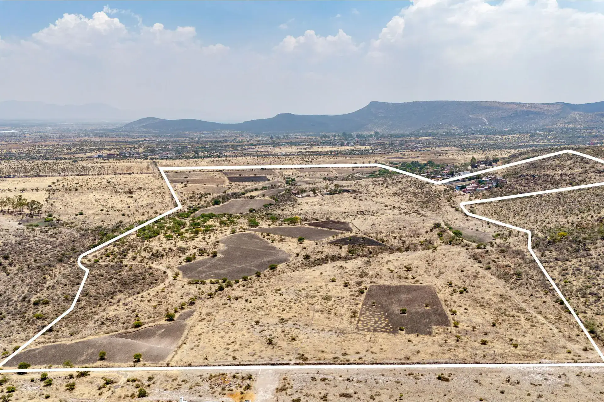 Rancho Guadalupe, wide aerial view of the outlined parcel with plowed plots and mountains on the horizon, San Miguel de Allende