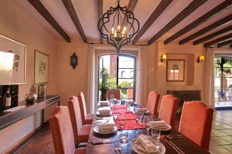 Rosewood Residence 7, dining room with orange upholstered chairs and a wrought-iron chandelier, San Miguel de Allende