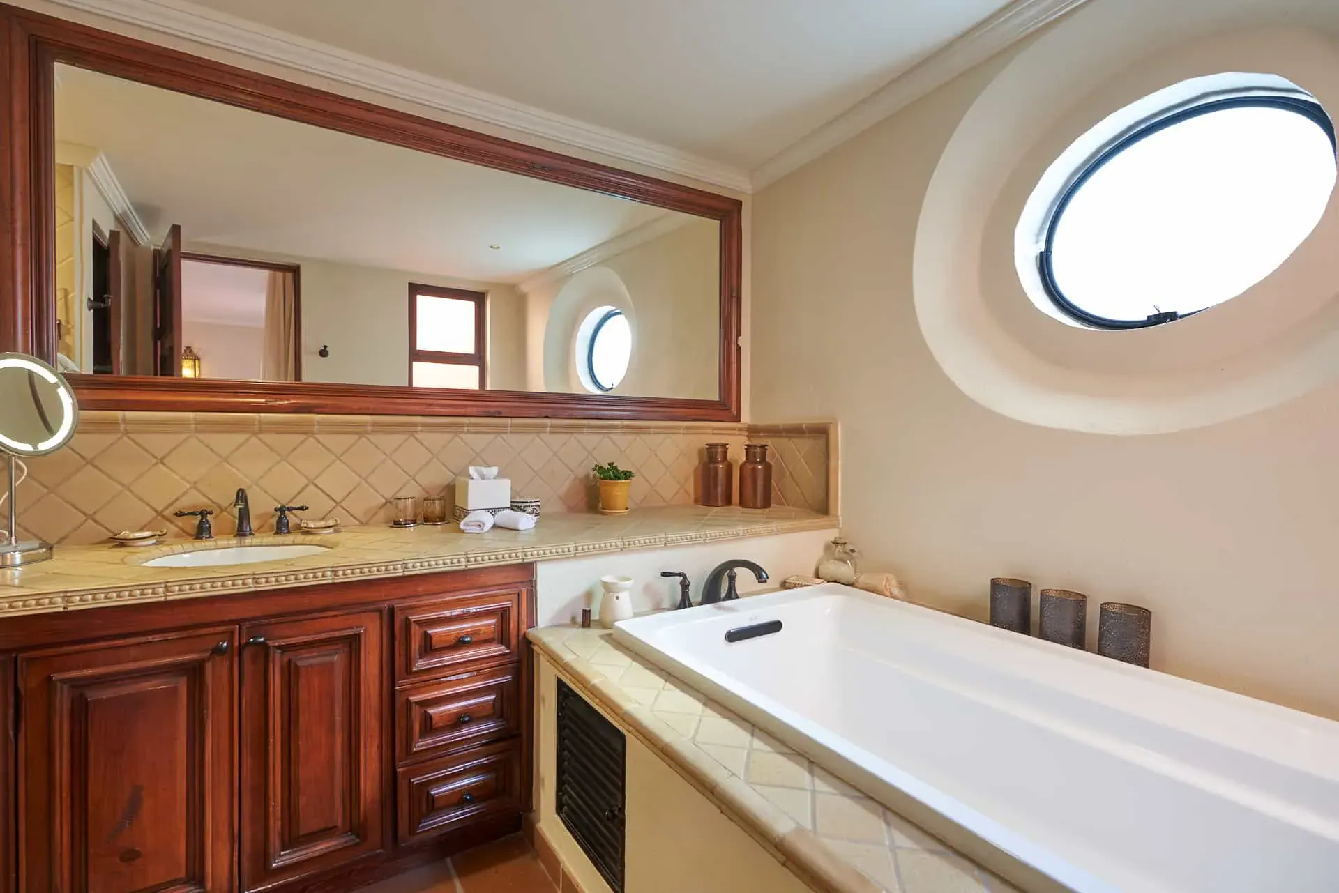 Rosewood Residence 7, bathroom with a soaking tub, a wood vanity and a round window, San Miguel de Allende