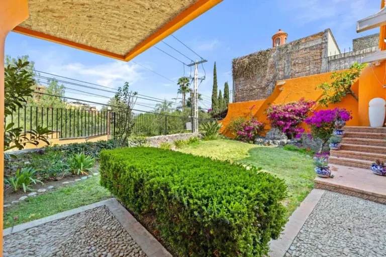 Santo Domingo House, lawn and hedge beside the orange house with bougainvillea and a stone stairway, San Miguel de Allende