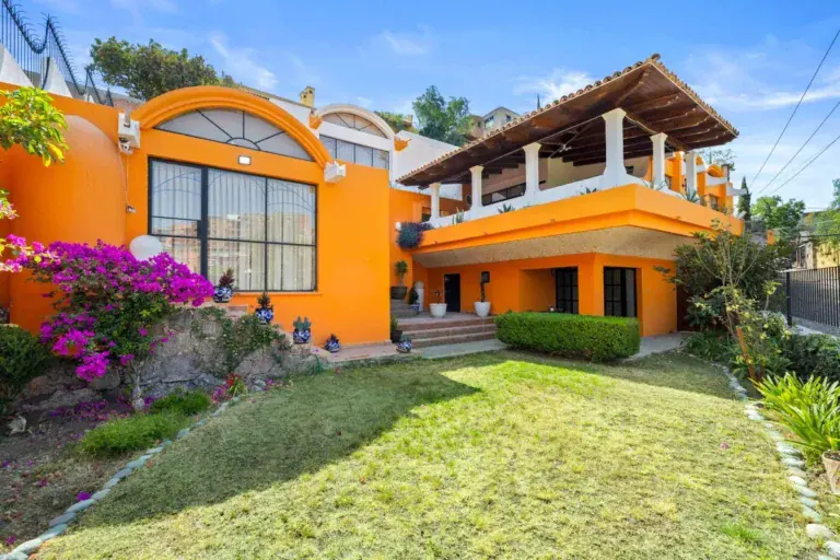 Santo Domingo House, back of the house with a covered upper terrace, a lawn and flowering bougainvillea, San Miguel de Allende