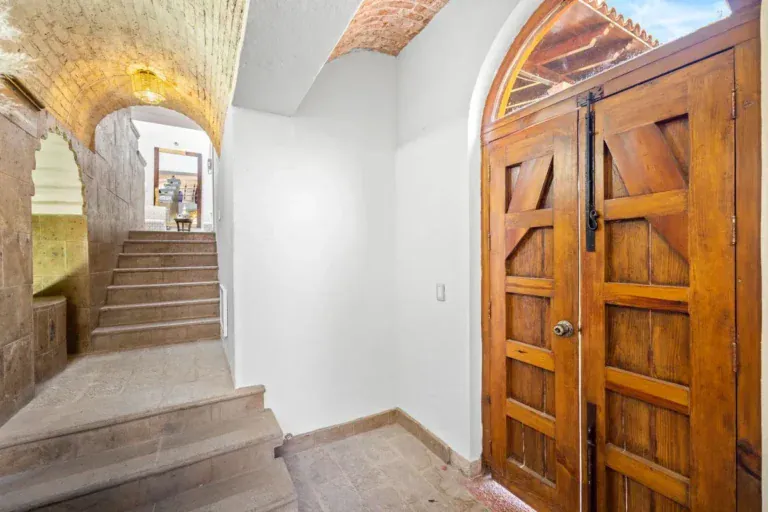 Santo Domingo House, entry with a double wooden door and a stone stairway under a brick vaulted ceiling, San Miguel de Allende