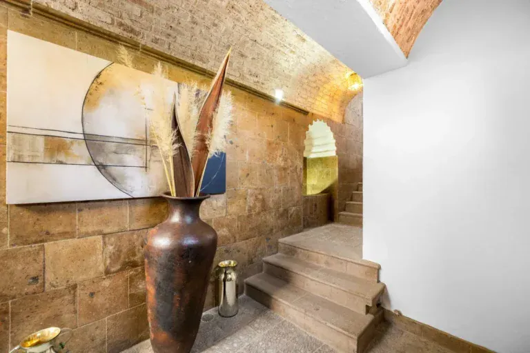 Santo Domingo House, stone-walled stairway with a tall bronze vase and an arched niche, San Miguel de Allende