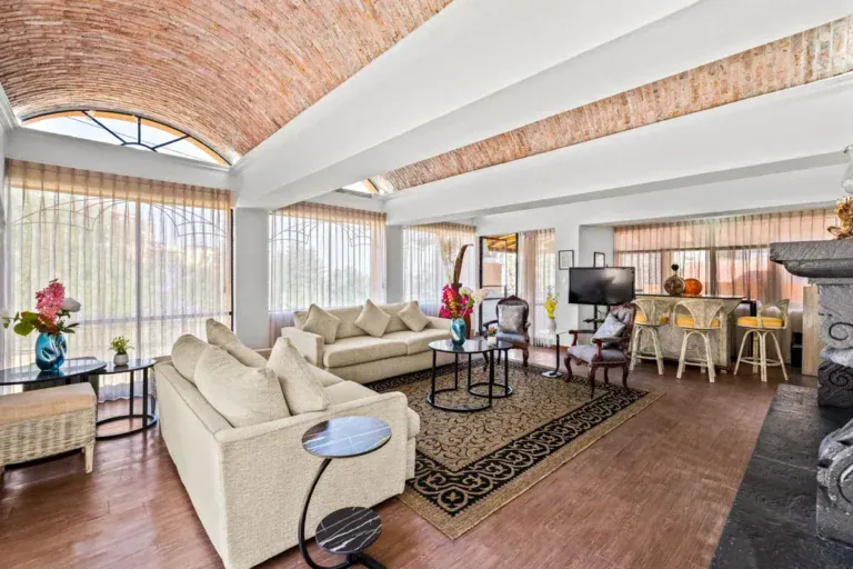 Santo Domingo House, living room with cream sofas, a black stone pedestal, arched windows and a brick vaulted ceiling, San Miguel de Allende