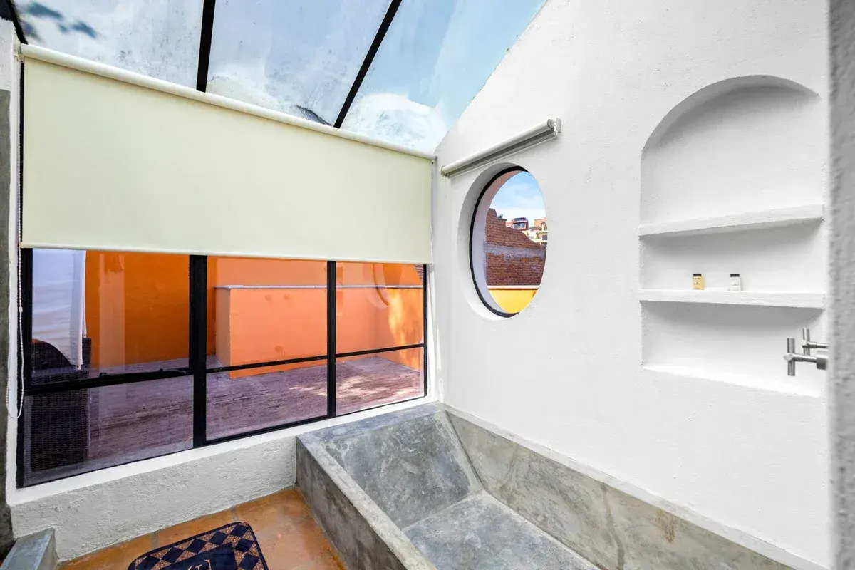 Santo Domingo House, bathroom with a stone soaking tub, a round window and a glass skylight, San Miguel de Allende