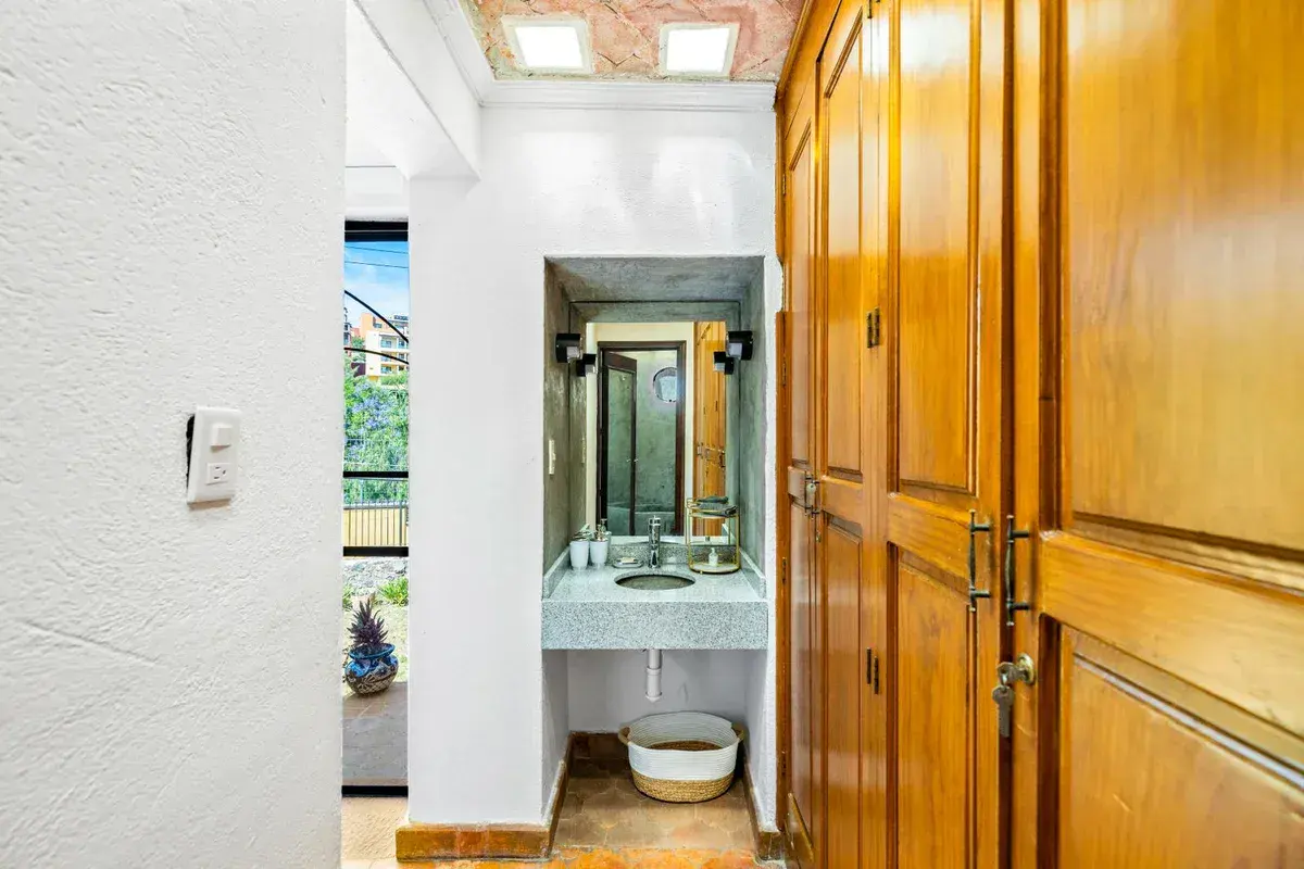 Santo Domingo House, dressing room with a tile sink, a skylight and tall wood wardrobe doors, San Miguel de Allende