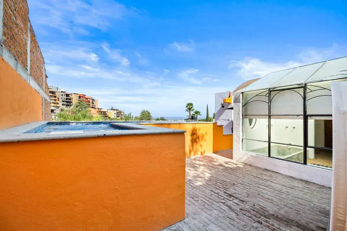 Santo Domingo House, roof terrace with an orange wall, a small plunge pool and a view toward the neighborhood, San Miguel de Allende