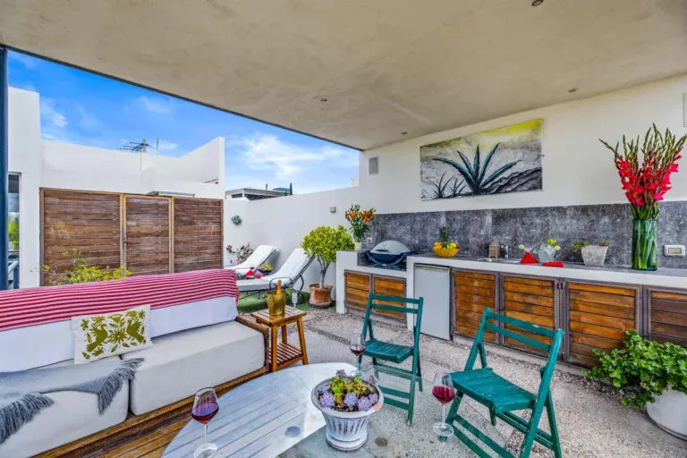 Outdoor lounge and kitchen terrace with a grill, wood cabinets and a sofa, San Miguel de Allende