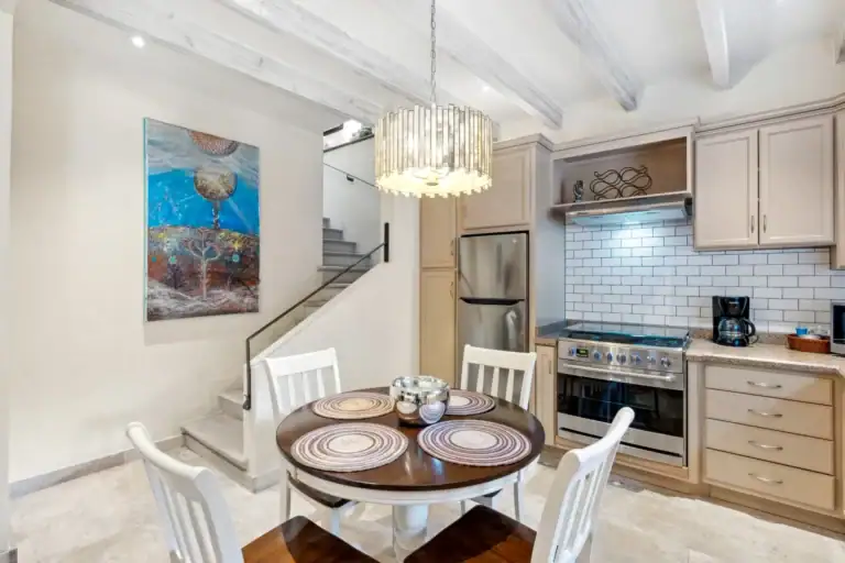 Suites Casa Vistas, dining table and open kitchen with a crystal pendant light and a staircase, San Miguel de Allende