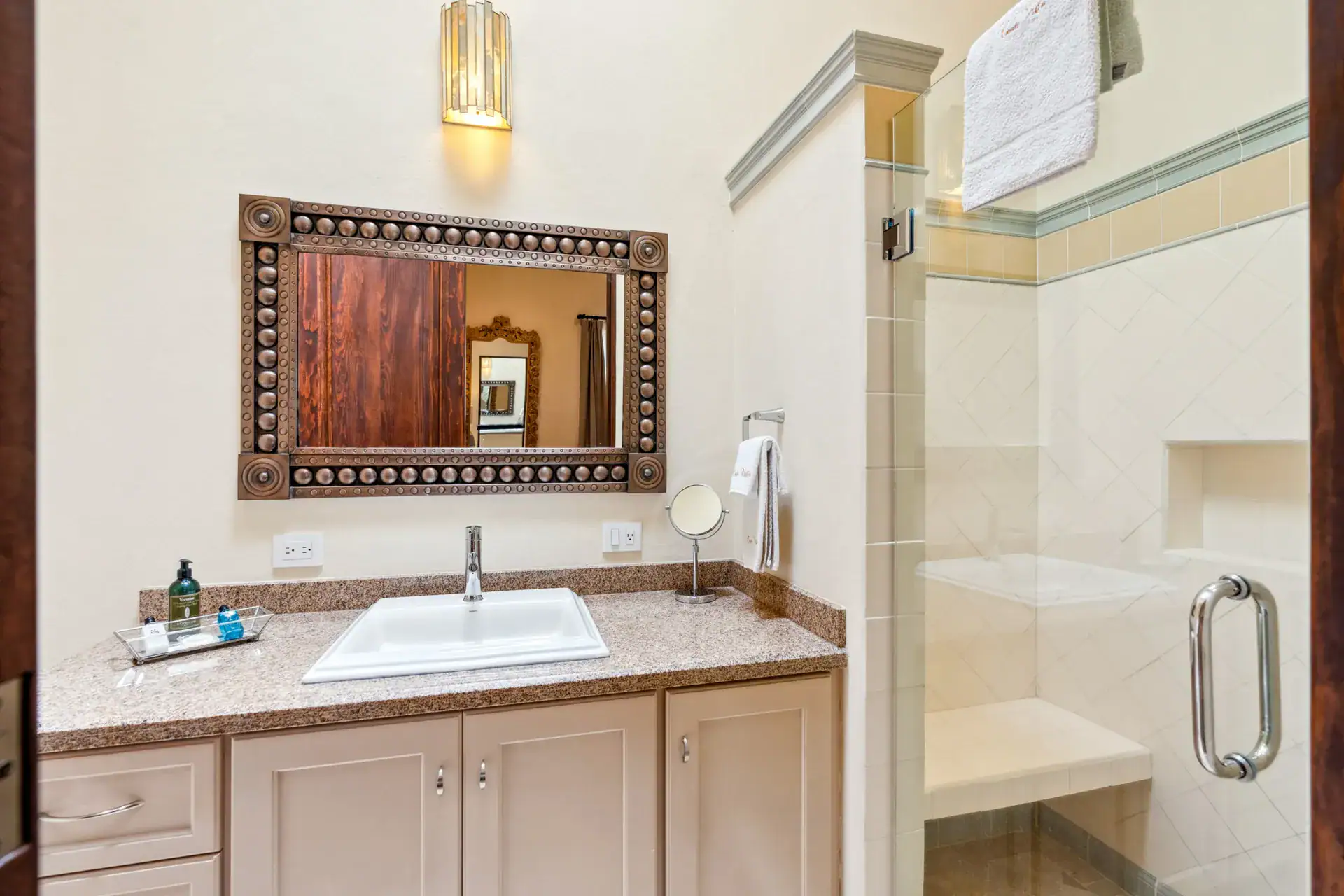 Suites Casa Vistas, bathroom with a beige vanity, studded wood-framed mirror and a glass shower, San Miguel de Allende