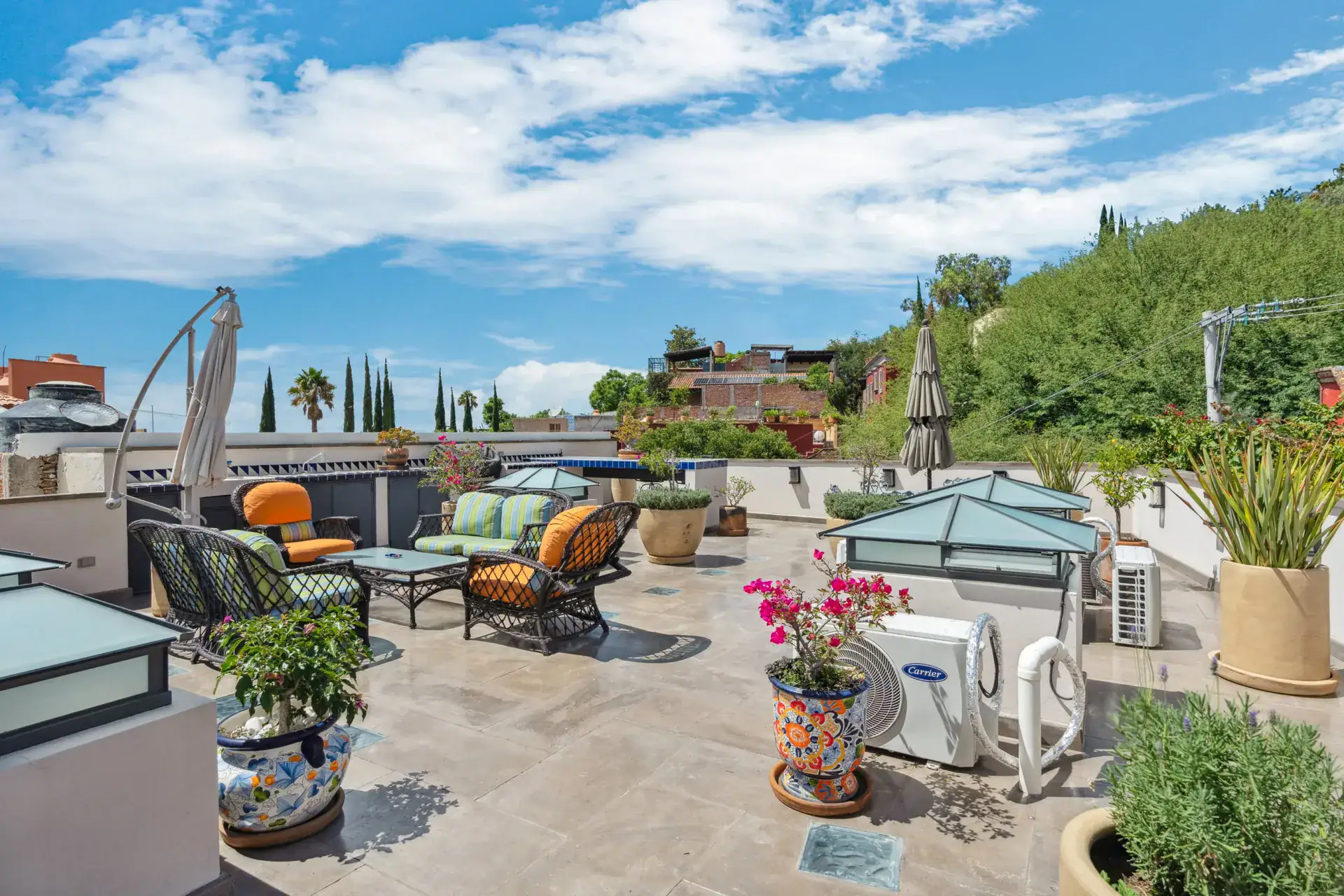 Suites Casa Vistas, rooftop terrace with wicker chairs, a skylight and potted plants under a blue sky, San Miguel de Allende