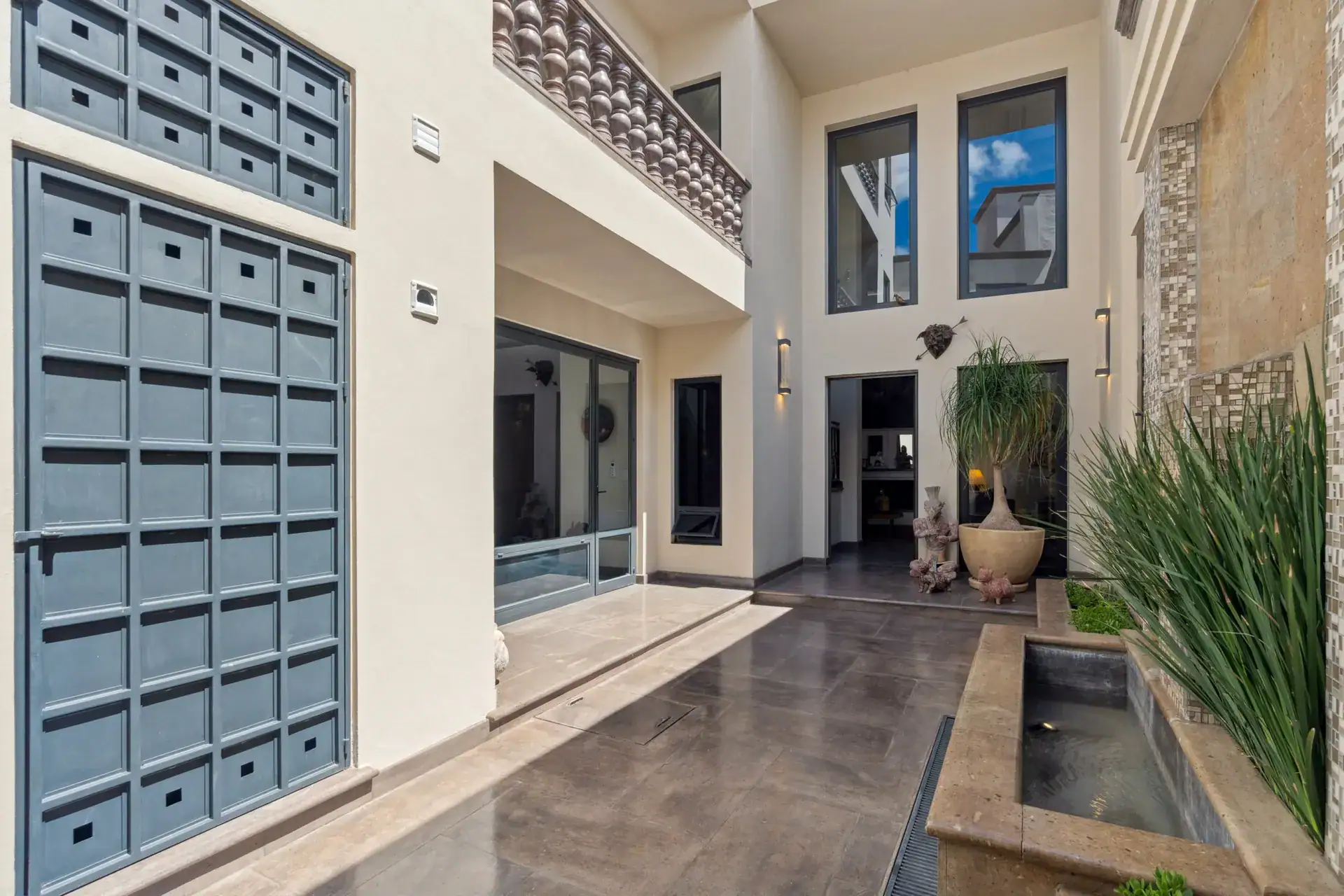 Suites Casa Vistas, courtyard with a blue grid-patterned wall, a water feature and a double-height facade, San Miguel de Allende