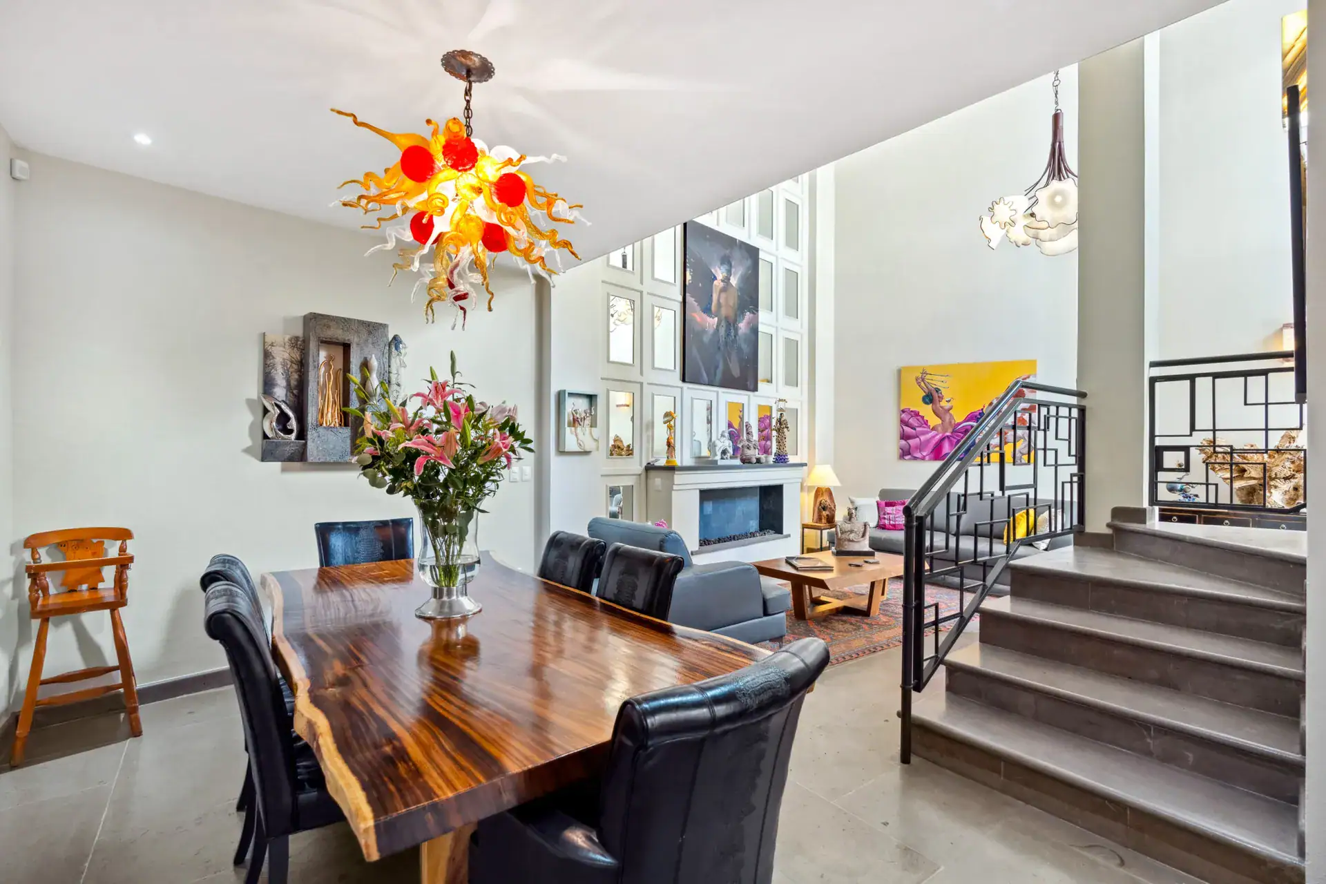 Suites Casa Vistas, dining table with black chairs beside a stepped seating area and a colorful chandelier, San Miguel de Allende