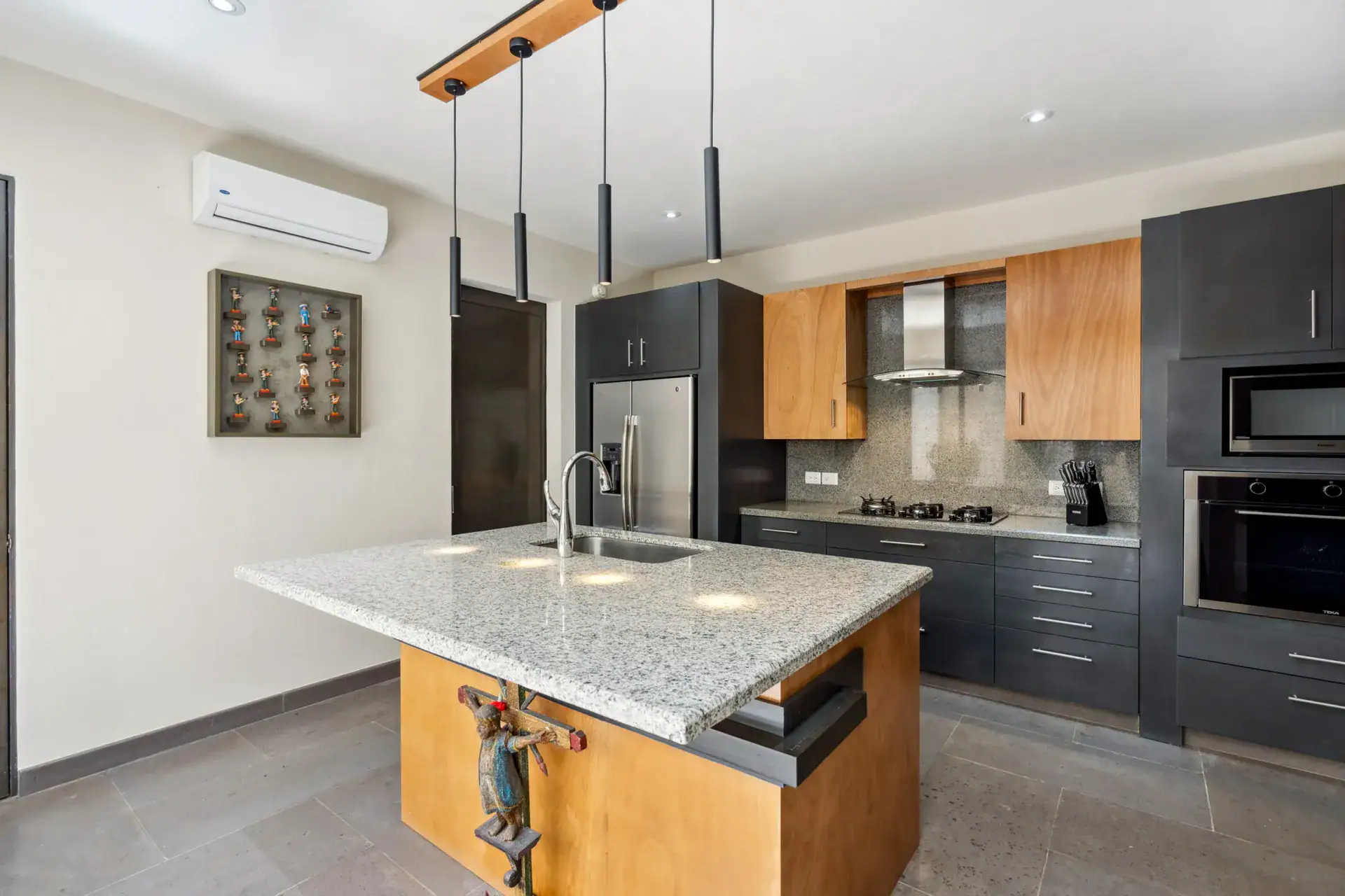 Suites Casa Vistas, kitchen with a granite island, dark cabinets, wood accents and a stainless refrigerator, San Miguel de Allende