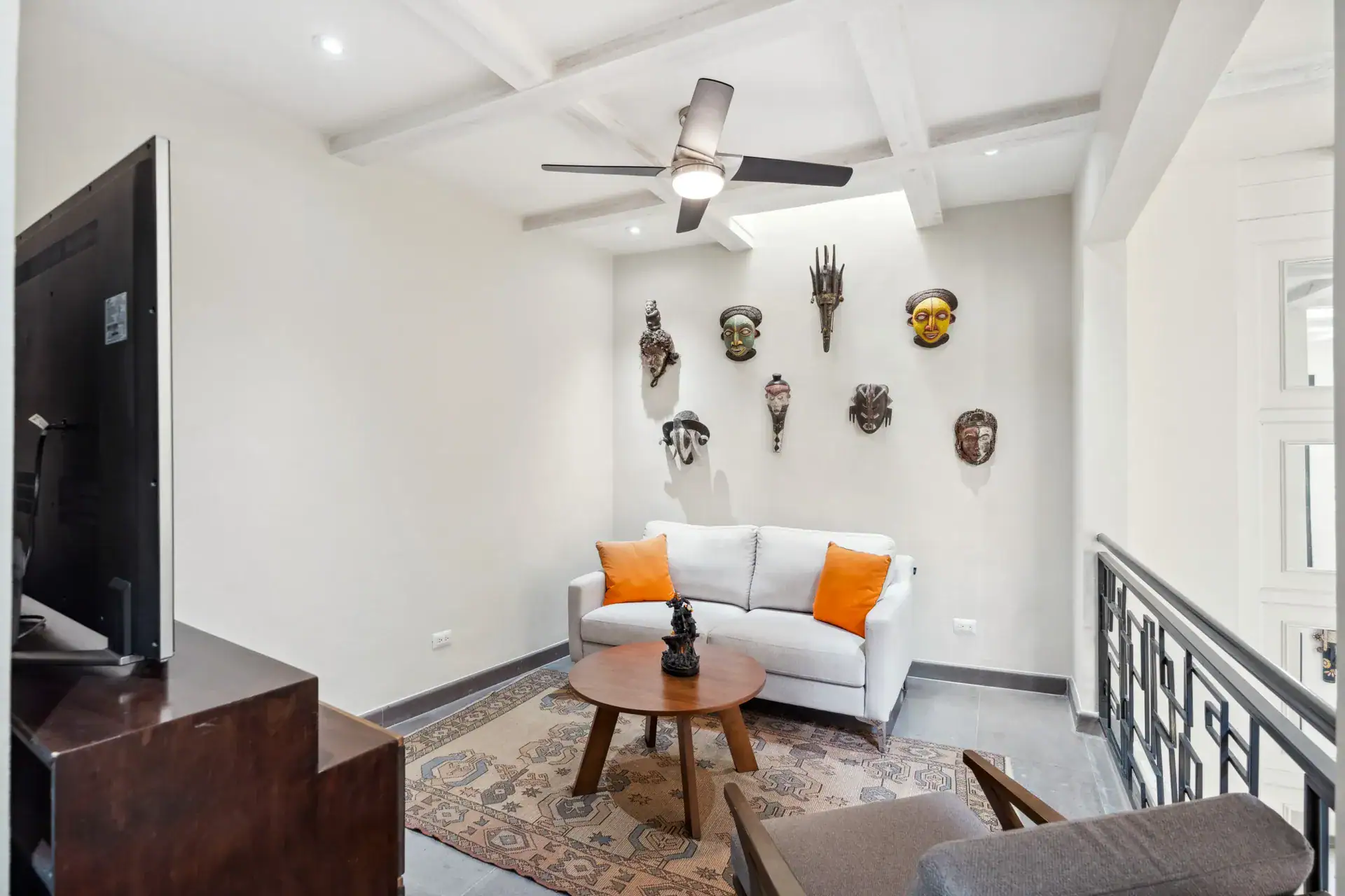 Suites Casa Vistas, loft sitting area with a white loveseat, wall masks and a ceiling fan, San Miguel de Allende