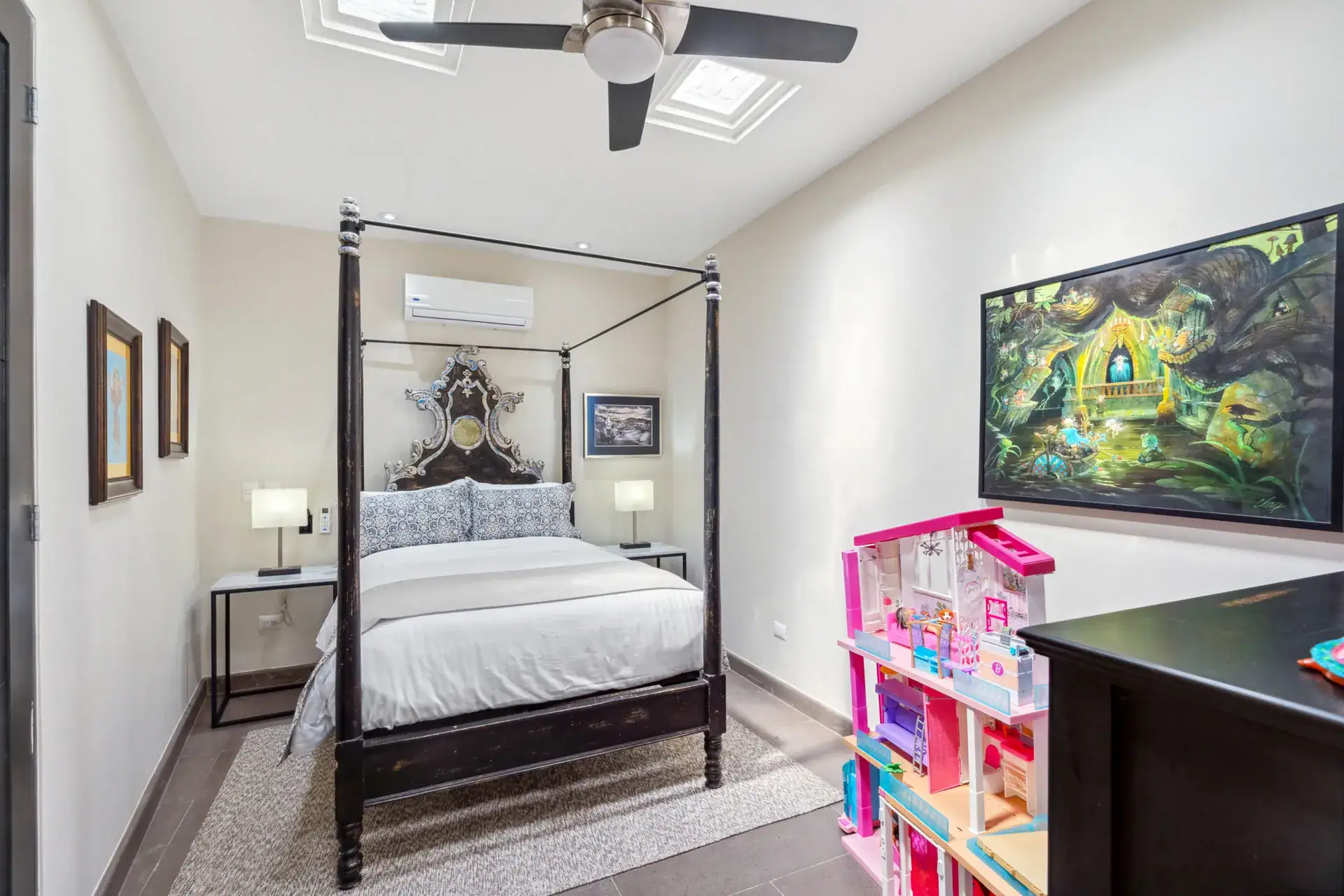 Suites Casa Vistas, bedroom with a black four-poster bed, large painting and a toy dollhouse, San Miguel de Allende