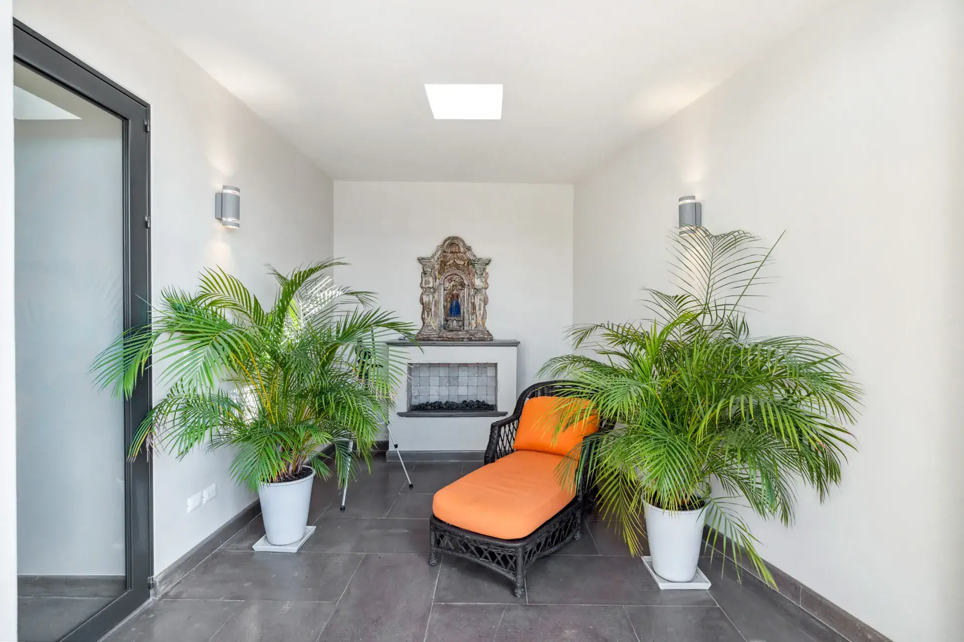 Suites Casa Vistas, meditation room with potted palms, an orange lounge chair and a small altar niche, San Miguel de Allende